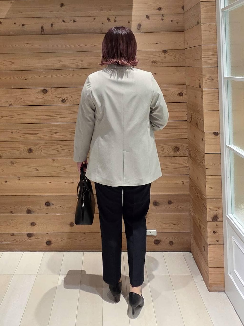 ブラック系のショルダーバッグ、ブラック系のパンプス、ブルー系のセットアップを着用したレディースの冬コーディネートの3枚目の写真