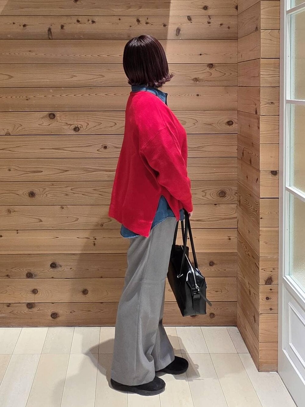 ブラック系のダウンジャケット/コート、ブラック系のボストンバッグ、ブルー系のシャツ/ブラウスを着用したレディースの冬コーディネートの2枚目の写真