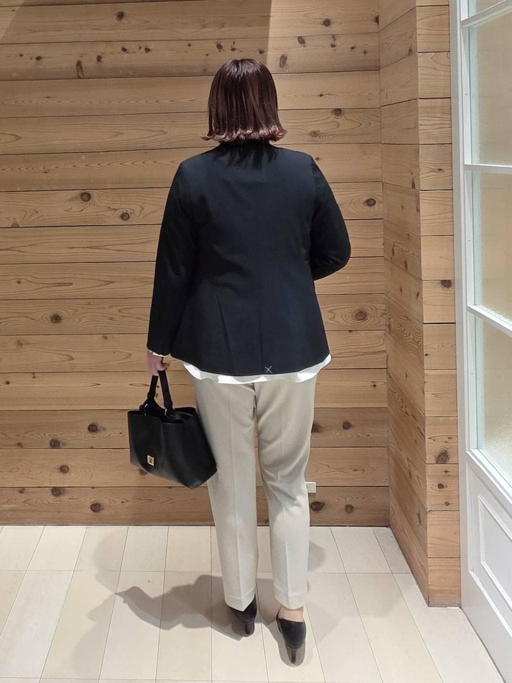 ブラック系のパンプス、ベージュ系のセットアップ、ブルー系のノーカラージャケットを着用したレディースの冬コーディネートの3枚目の写真