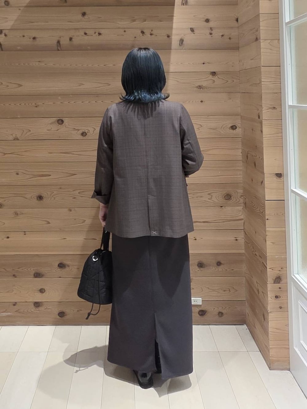 ブラック系のローファー、ブラック系のハンドバッグ、ブルー系のTシャツ/カットソーを着用したレディースの秋コーディネートの3枚目の写真