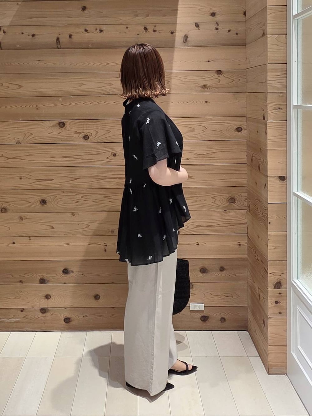 ベージュ系のその他パンツ、ホワイト系のタンクトップ、ブラック系のクラッチバッグを着用したレディースの夏コーディネートの2枚目の写真