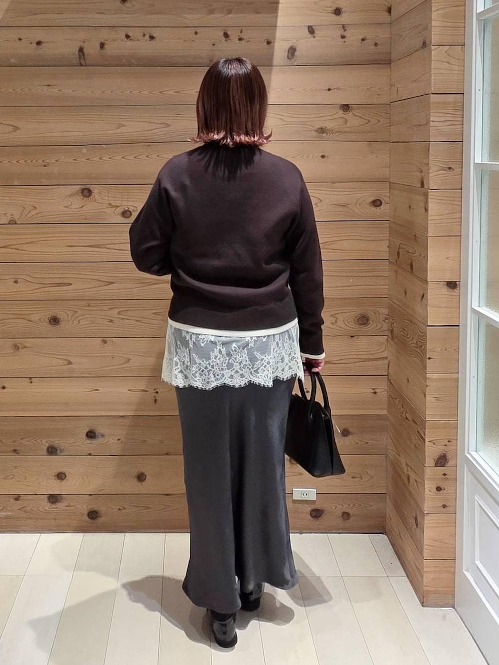 ブラック系のローファー、ブラック系のショルダーバッグ、グレー系のスカートを着用したレディースの冬コーディネートの3枚目の写真