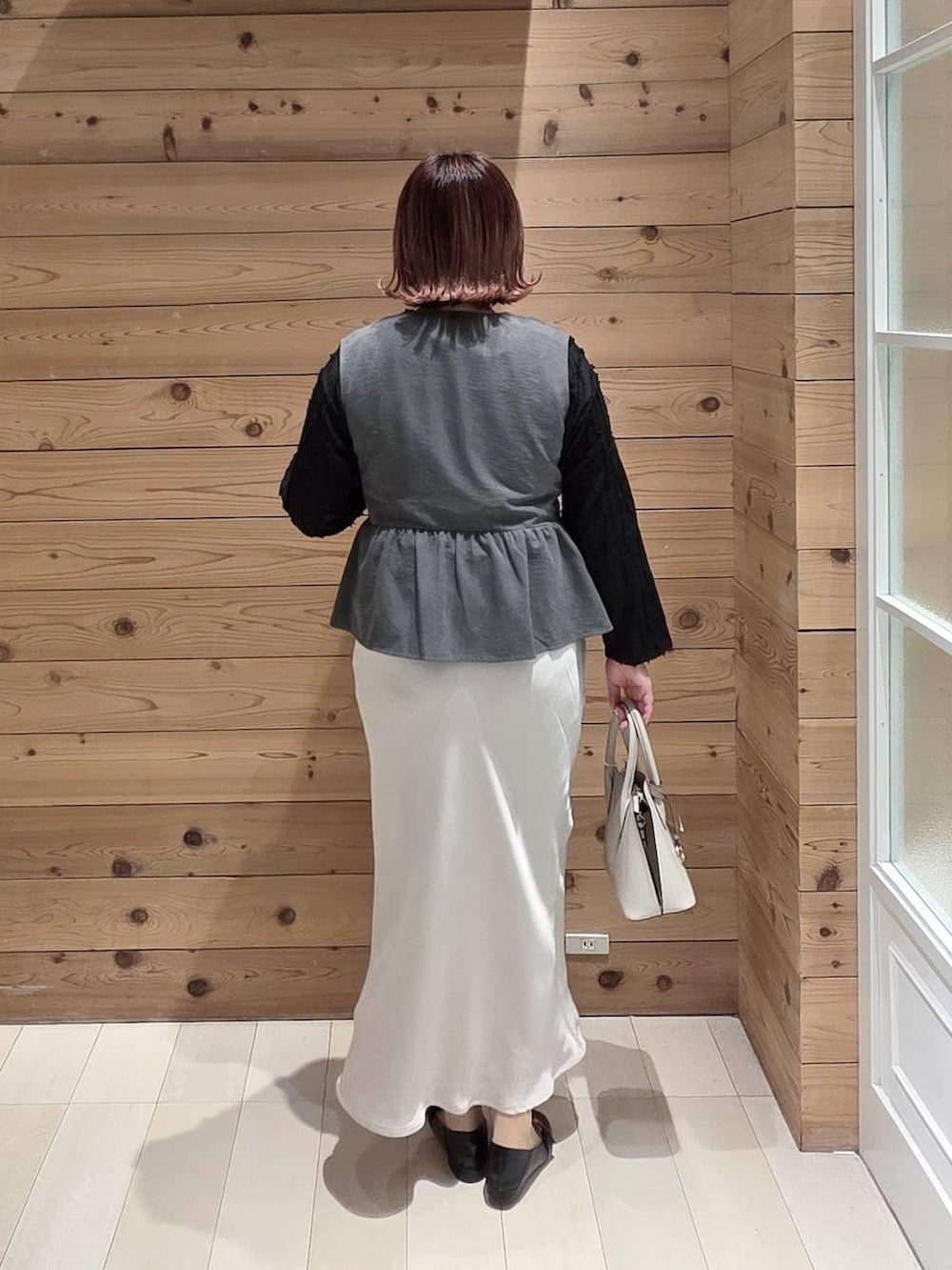 ブラック系のローファー、ホワイト系のショルダーバッグ、ブラック系のTシャツ/カットソーを着用したレディースの冬コーディネートの3枚目の写真