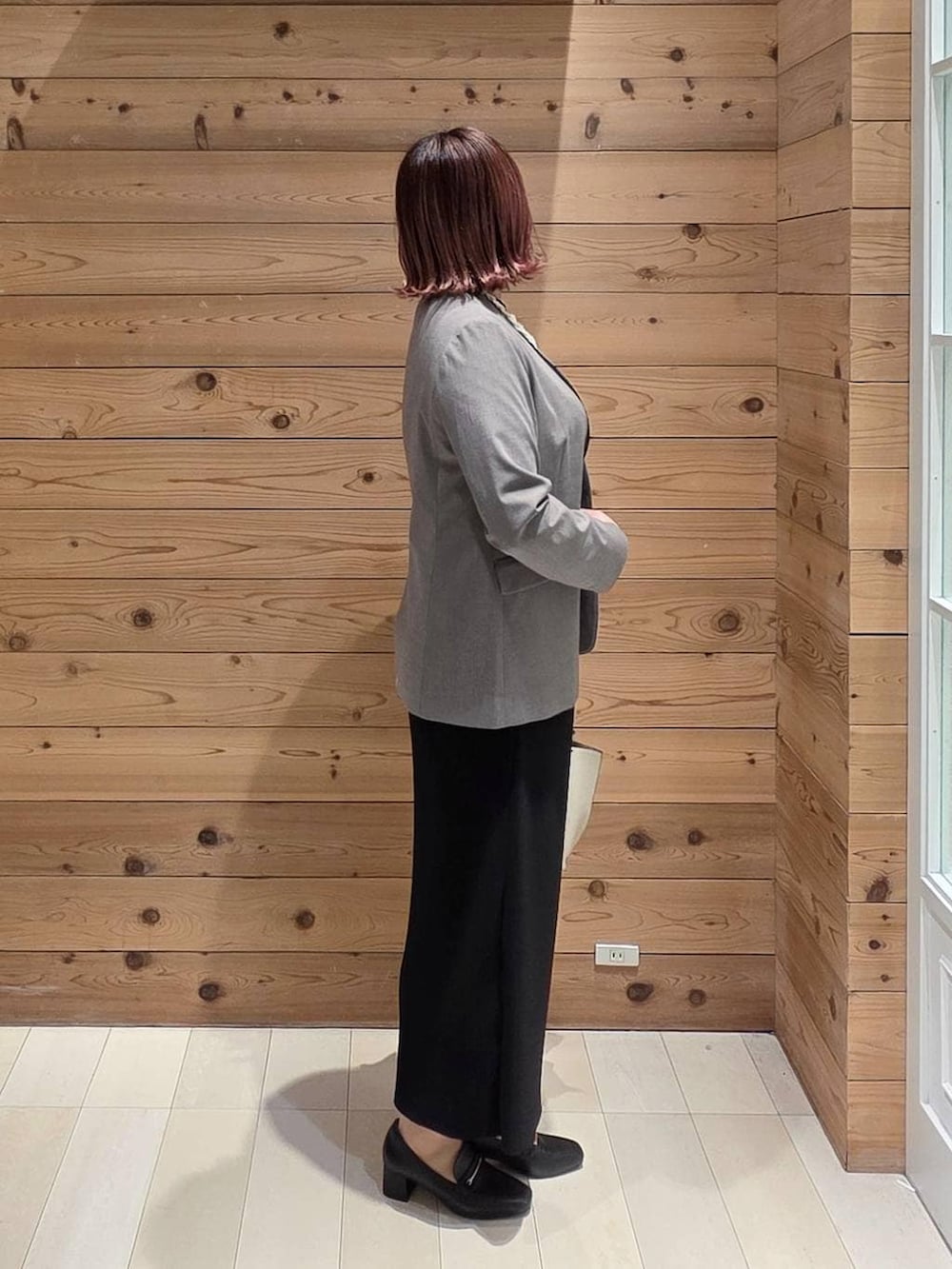 ブラック系のローファー、ホワイト系のトートバッグ、ブラウン系のノーカラージャケットを着用したレディースの冬コーディネートの2枚目の写真