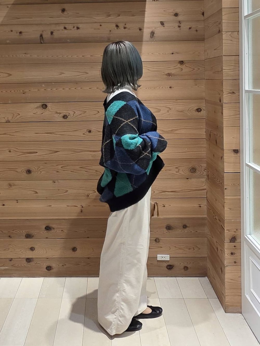 ブラック系のバレエシューズ、ブラウン系のボストンバッグ、ブラック系のカーディガン/ボレロを着用したレディースの秋コーディネートの2枚目の写真