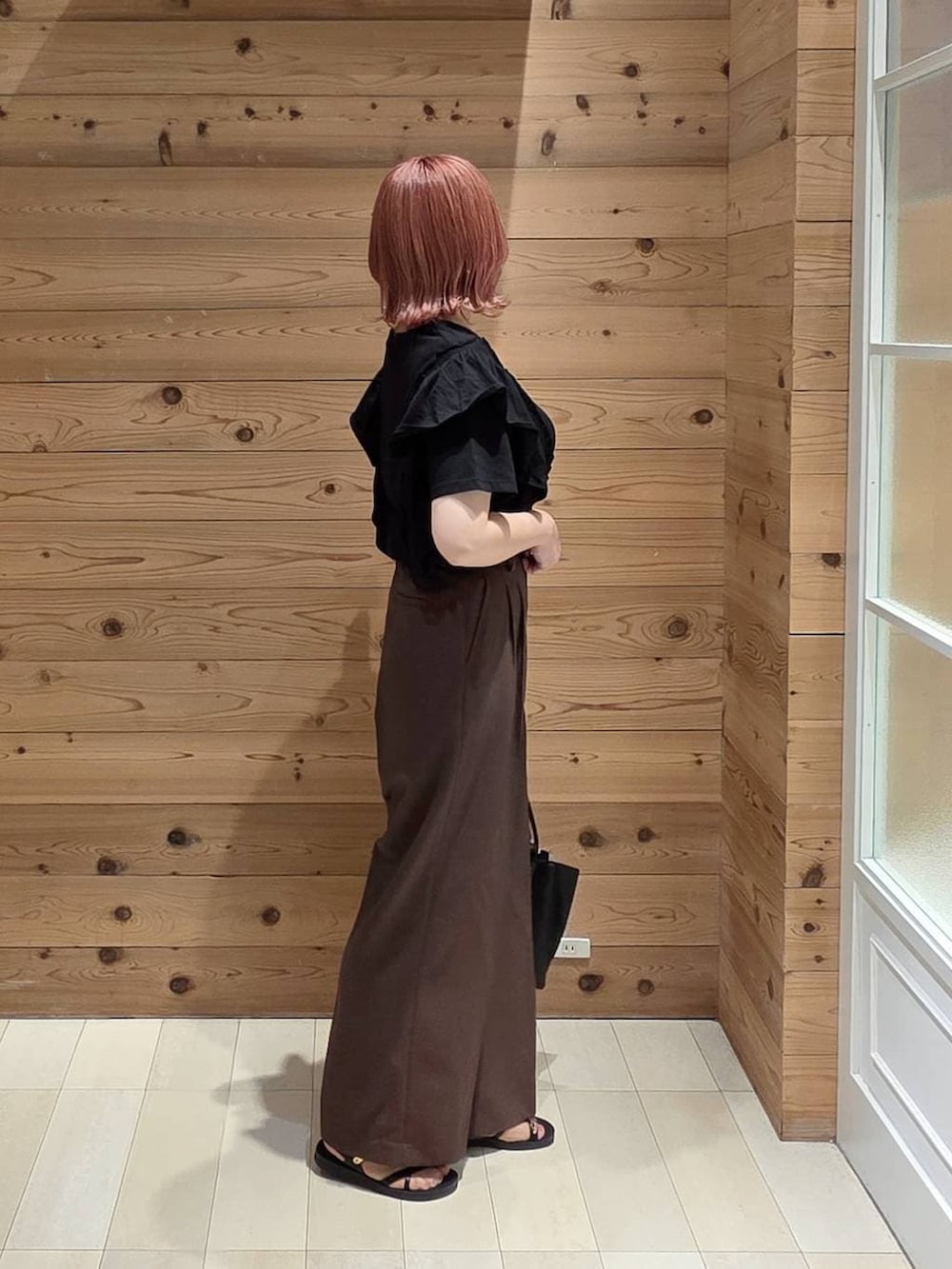 ブラック系のトートバッグ、ブラウン系のその他パンツ、ブラック系のTシャツ/カットソーを着用したレディースの夏コーディネートの2枚目の写真
