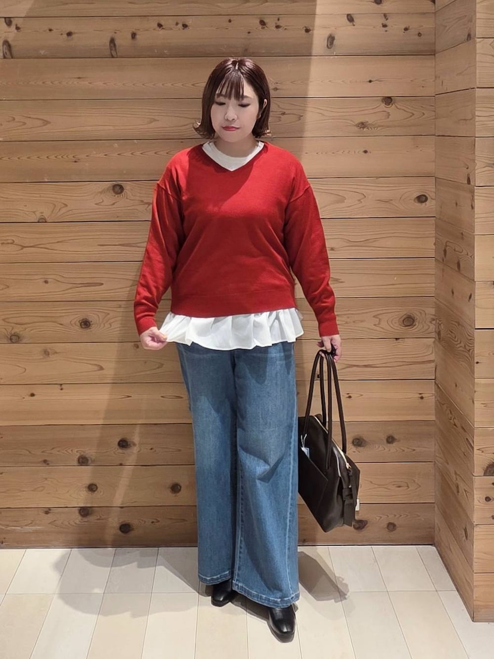 ベージュ系のダウンジャケット/コート、ブラウン系のボストンバッグ、ホワイト系のTシャツ/カットソーを着用したレディースの冬コーディネートの4枚目の写真