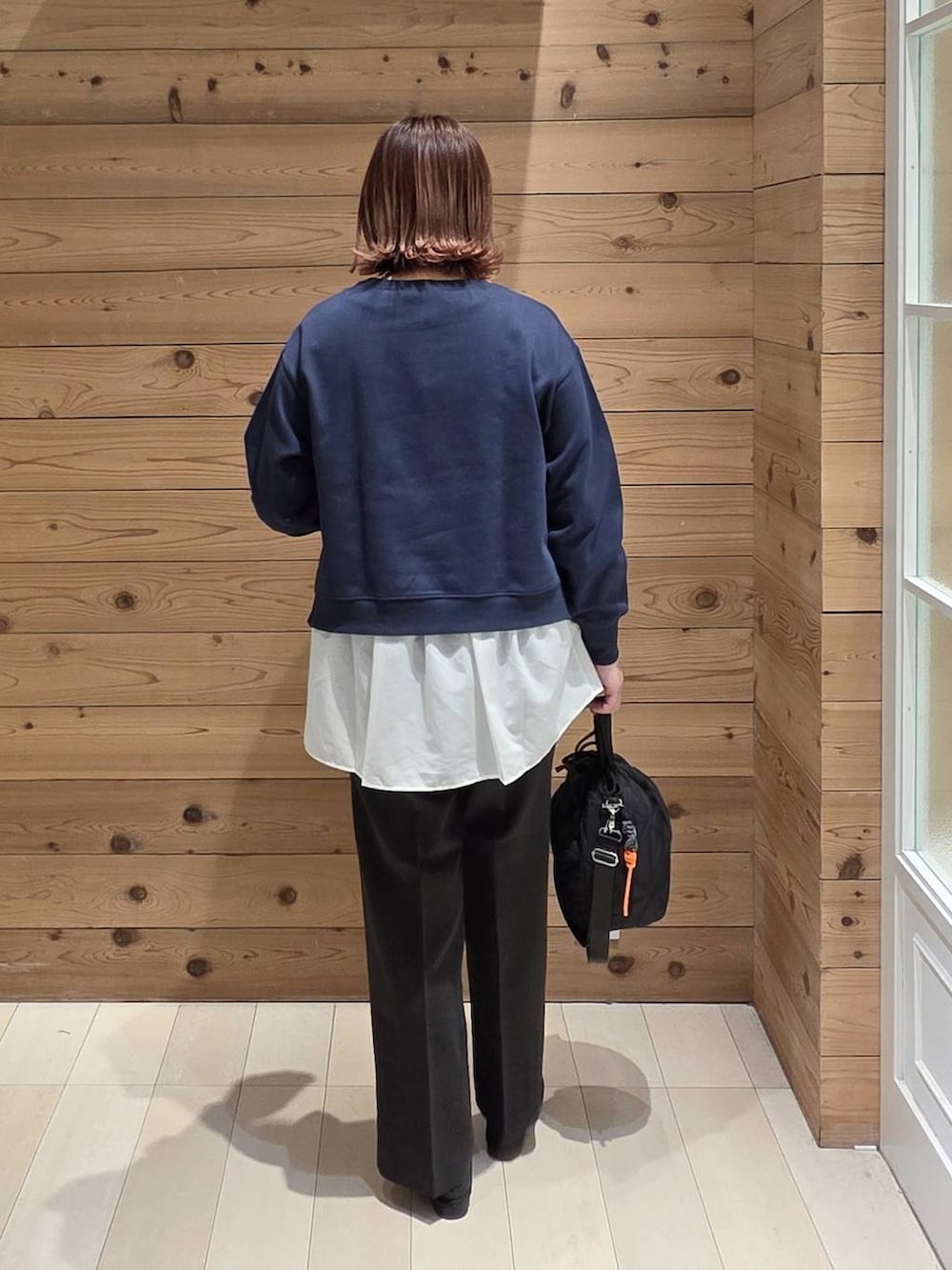 ブラック系のローファー、ブラック系のハンドバッグ、ブルー系のスウェットを着用したレディースの春コーディネートの4枚目の写真