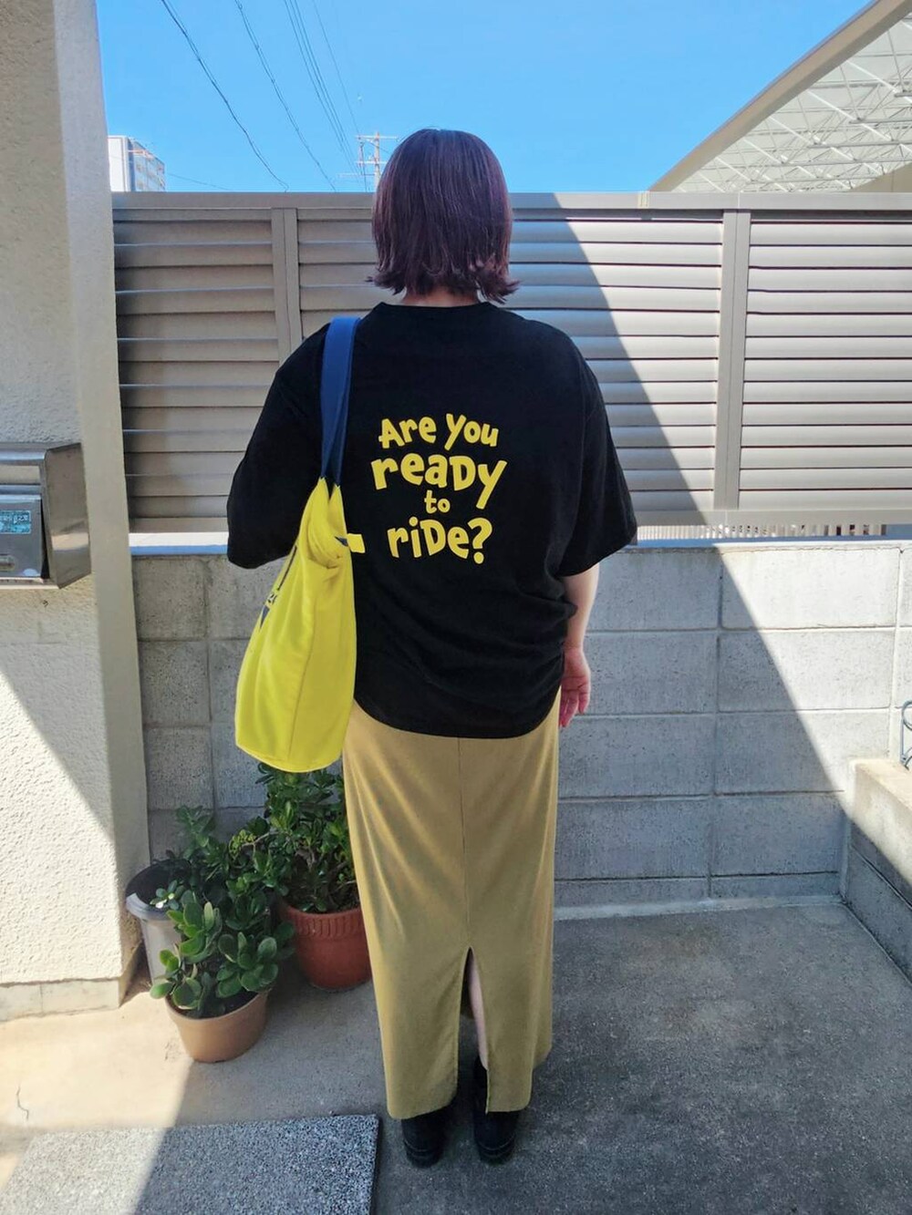 イエロー系のスカートを着用したレディースの夏コーディネートの2枚目の写真