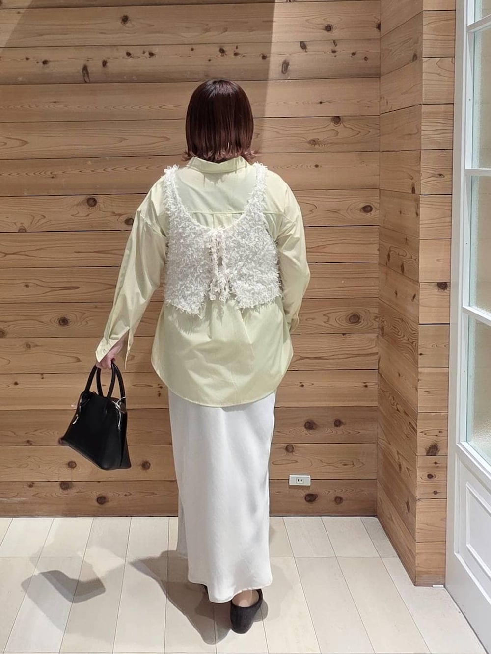 ブラック系のバレエシューズ、ブラック系のショルダーバッグ、イエロー系のシャツ/ブラウスを着用したレディースの春コーディネートの3枚目の写真