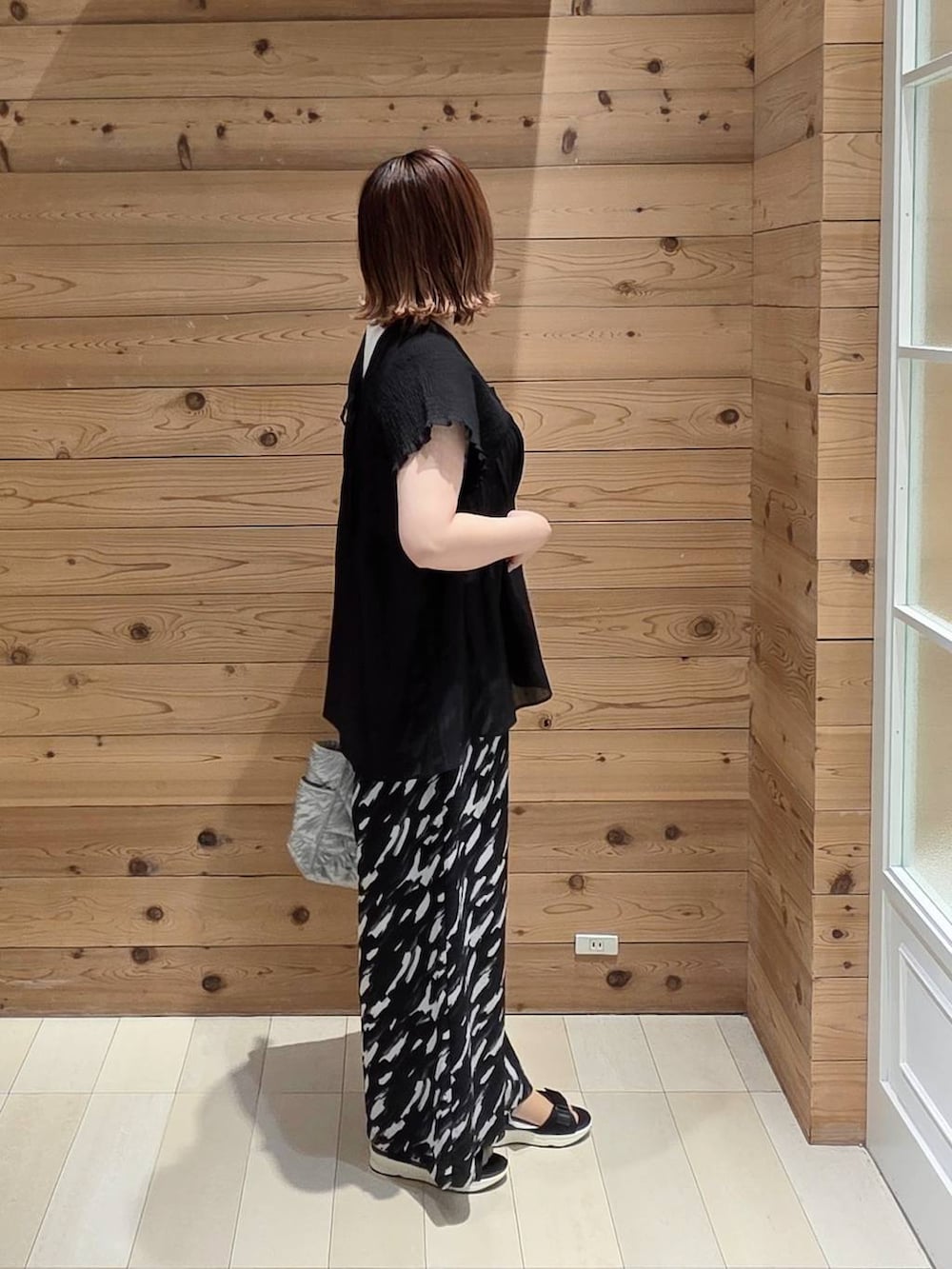 シルバー系のトートバッグ、ブルー系のその他パンツ、ホワイト系のタンクトップを着用したレディースの夏コーディネートの2枚目の写真