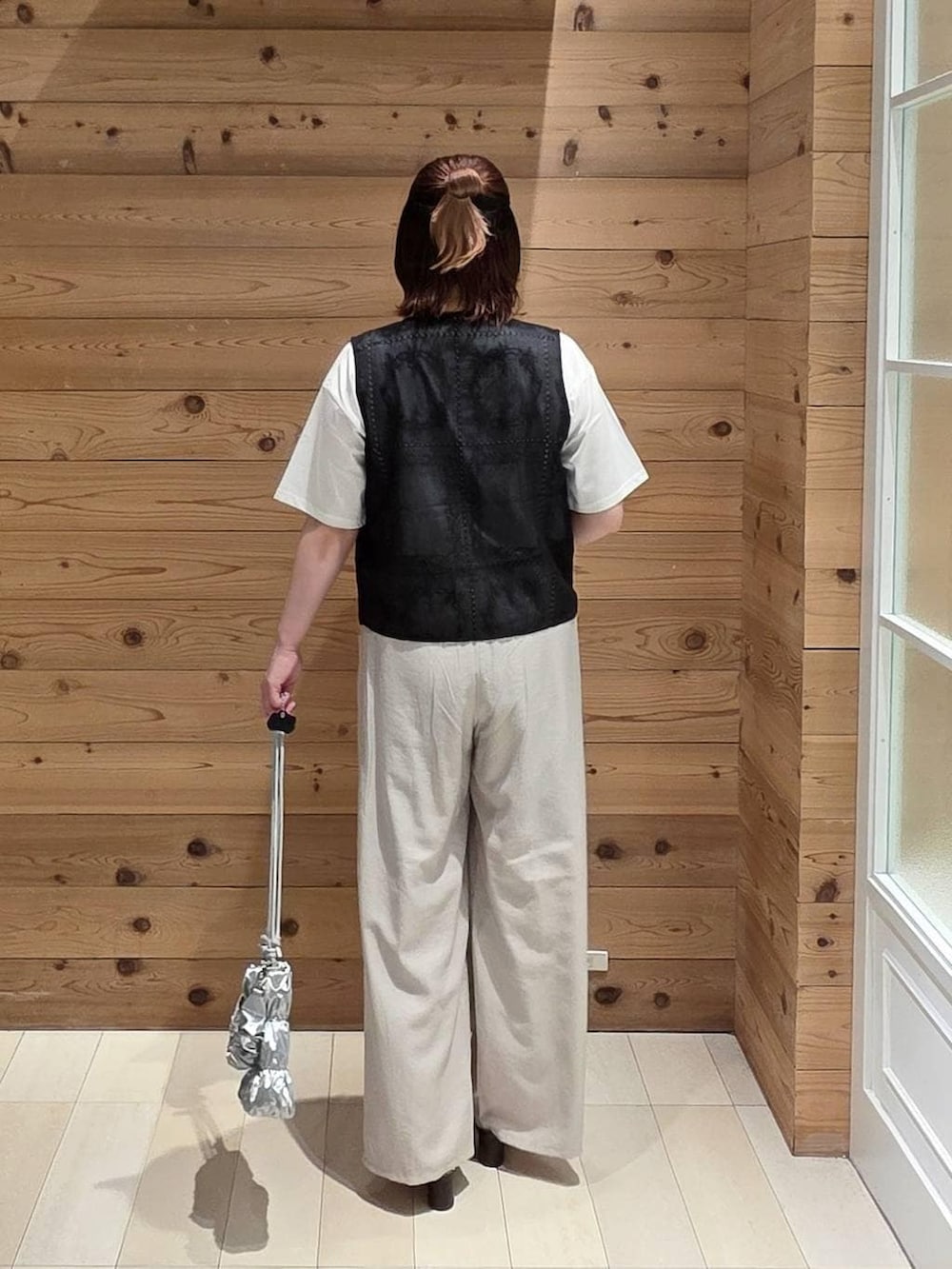 ベージュ系のその他パンツ、ホワイト系のTシャツ/カットソー、ブラウン系のサンダルを着用したレディースの夏コーディネートの3枚目の写真