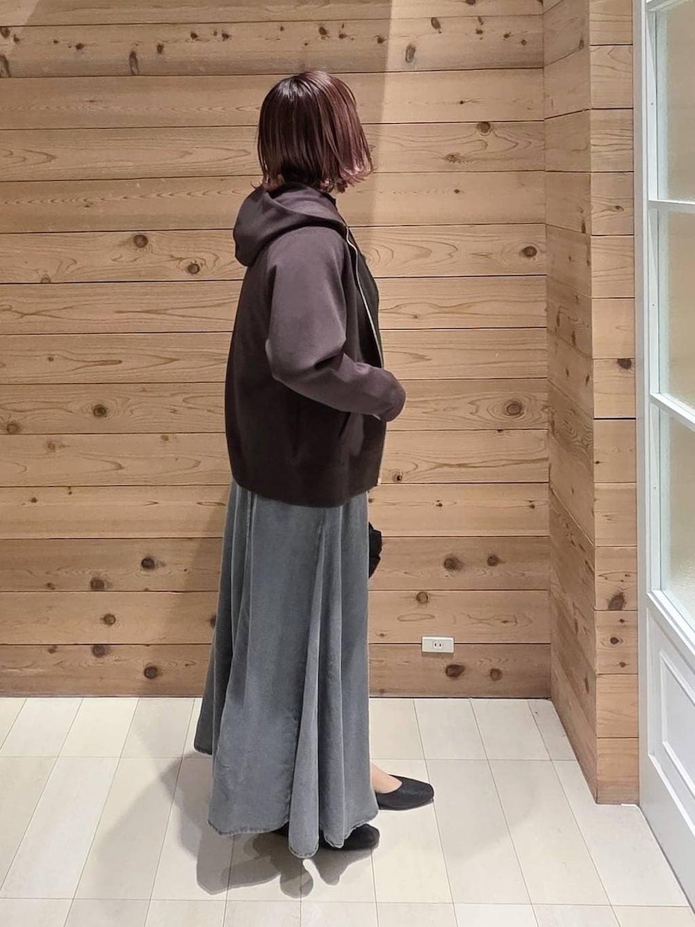 ブラック系のパンプス、ブラック系のトートバッグ、ブラウン系のパーカーを着用したレディースの冬コーディネートの2枚目の写真