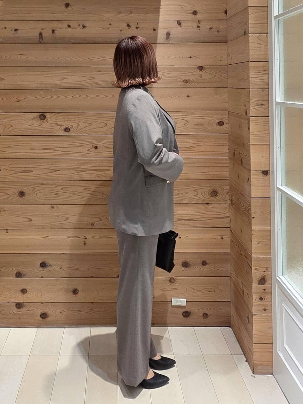 ブラック系のパンプス、ブラウン系のスラックス、ブラック系のシャツ/ブラウスを着用したレディースの冬コーディネートの2枚目の写真