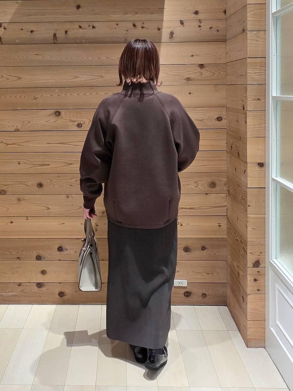 ブラック系のローファー、ホワイト系のショルダーバッグ、ホワイト系のTシャツ/カットソーを着用したレディースの冬コーディネートの3枚目の写真