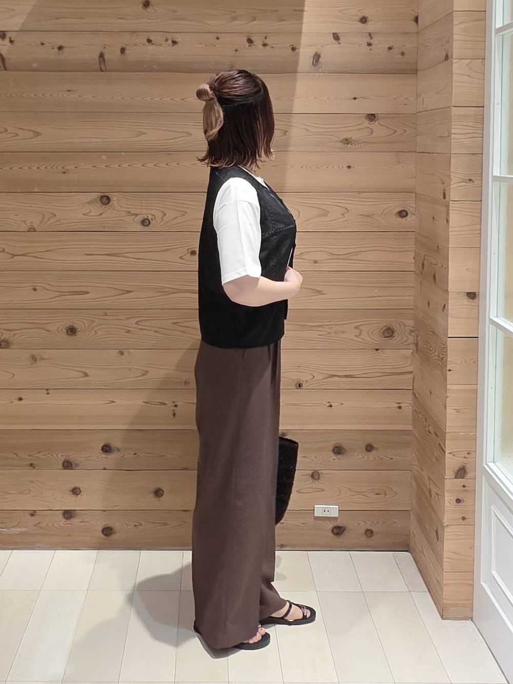 ブラウン系のその他パンツ、ホワイト系のTシャツ/カットソー、ブラック系のクラッチバッグを着用したレディースの夏コーディネートの2枚目の写真