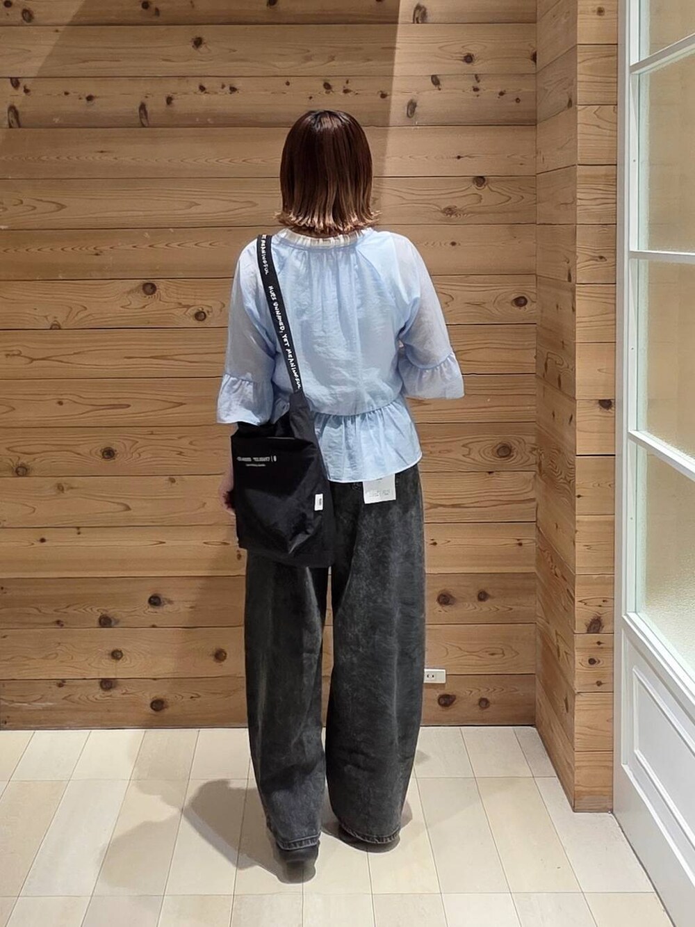 ブラック系のデニムパンツ、ホワイト系のタンクトップ、ホワイト系のサンダルを着用したレディースの夏コーディネートの3枚目の写真