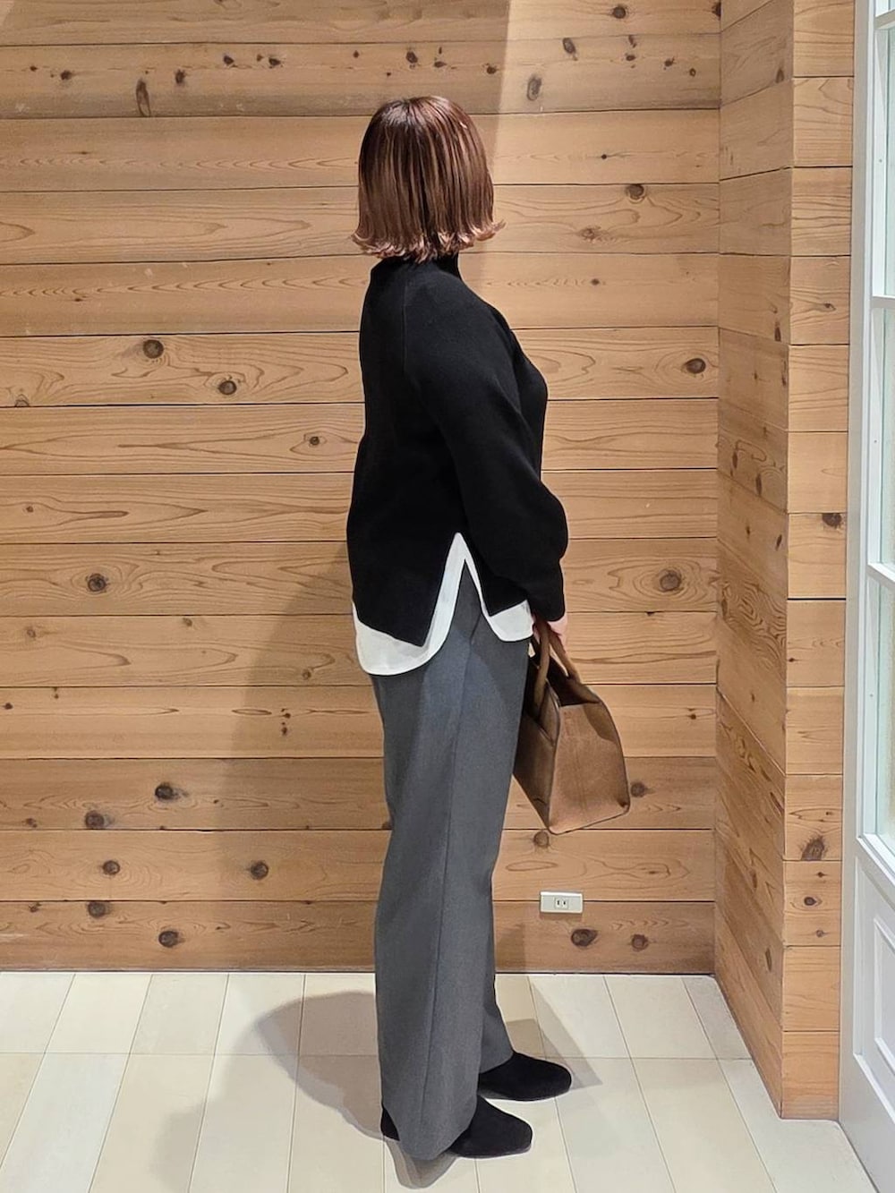 グレー系のチェスターコート、グレー系のその他パンツ、ベージュ系のショルダーバッグを着用したレディースの冬コーディネートの2枚目の写真