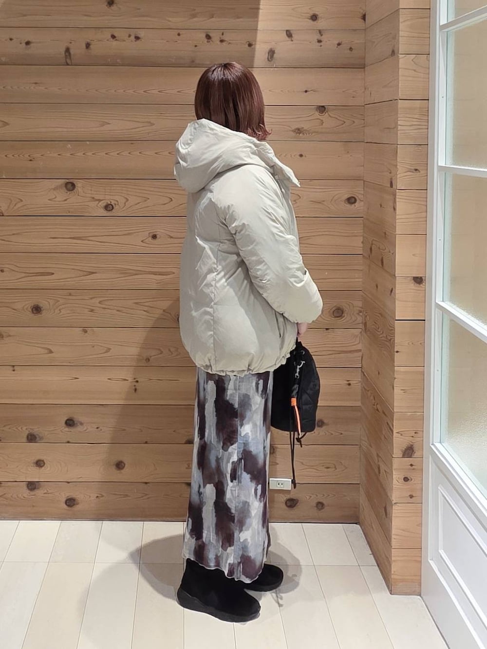 ベージュ系のダウンジャケット/コート、ブラック系のハンドバッグ、ブラック系のブーツを着用したレディースの冬コーディネートの2枚目の写真