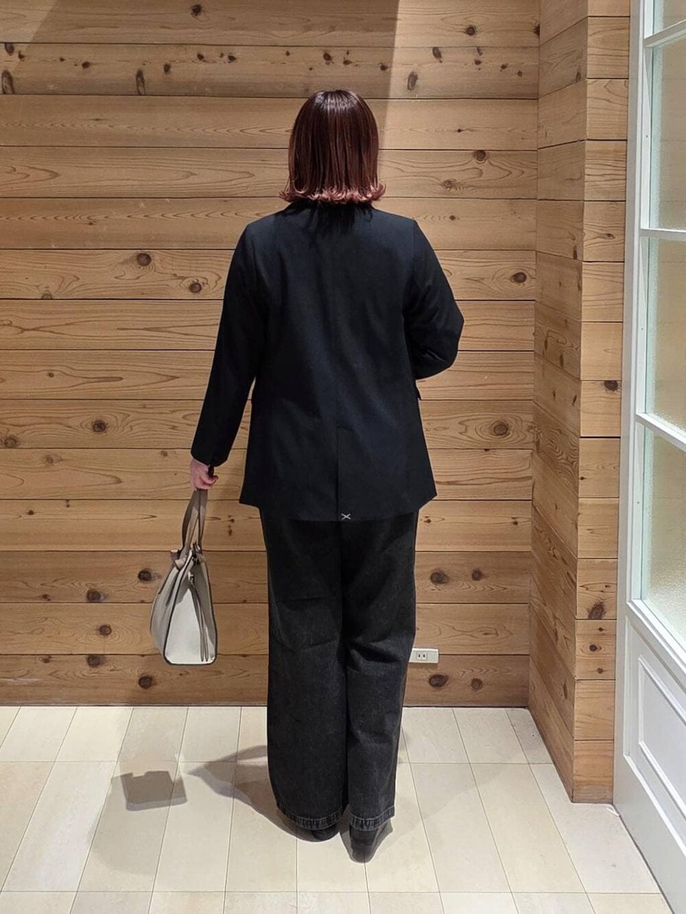 ブラック系のローファー、ホワイト系のショルダーバッグ、ブラック系のデニムパンツを着用したレディースの冬コーディネートの3枚目の写真