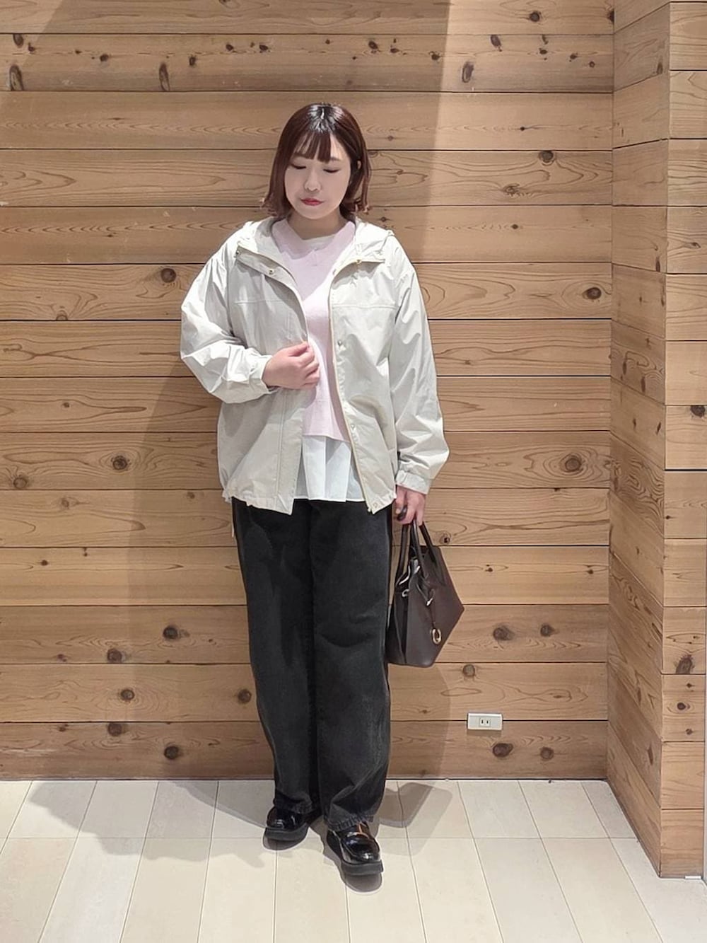 ブラック系のローファー、ブラウン系のショルダーバッグ、ベージュ系のマウンテンパーカーを着用したレディースの春コーディネートの4枚目の写真