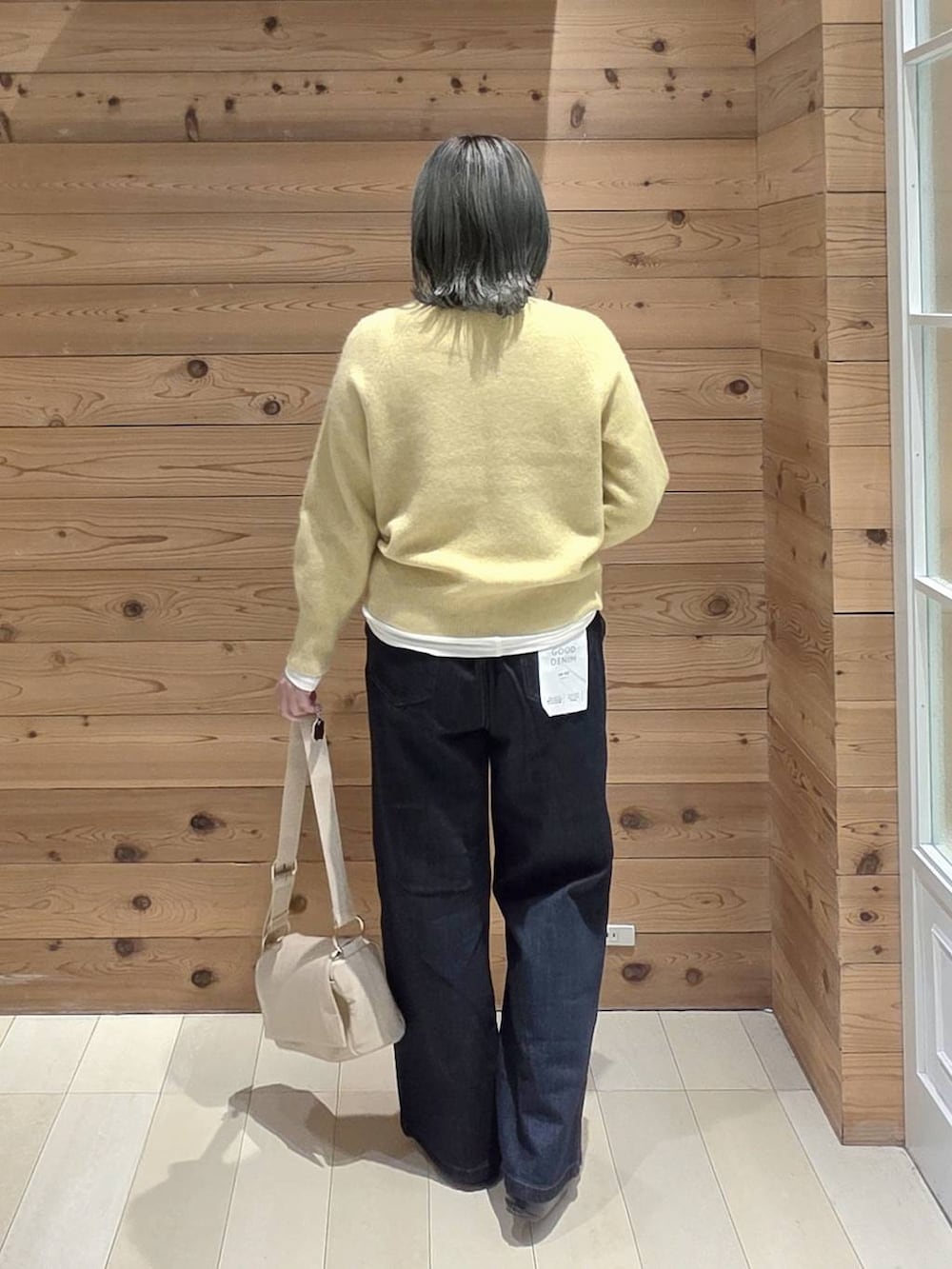 ブラック系のバレエシューズ、ブルー系のデニムパンツ、イエロー系のニット/セーターを着用したレディースの秋コーディネートの3枚目の写真