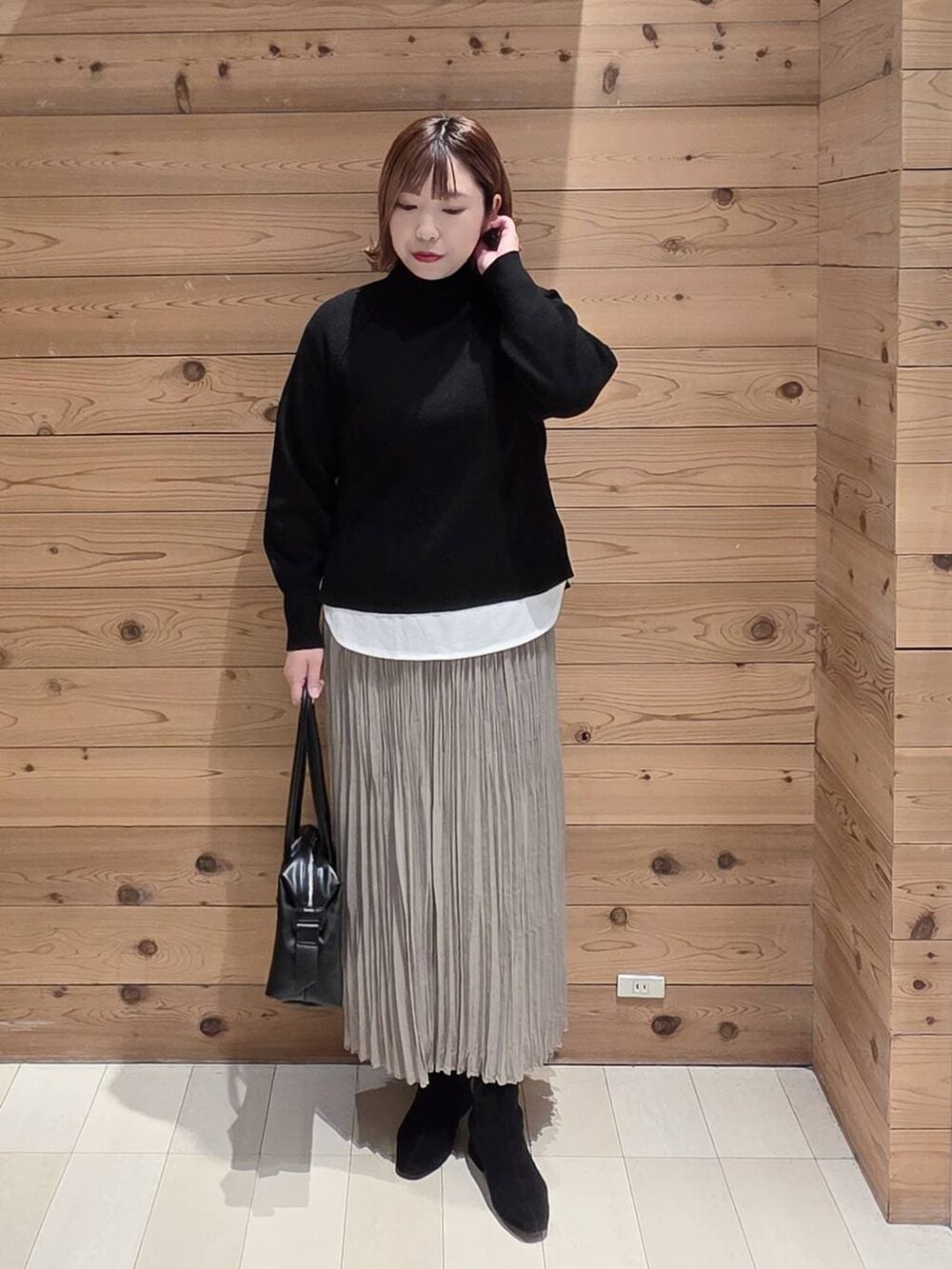 ブラック系のダウンジャケット/コート、ブラック系のボストンバッグ、ホワイト系のTシャツ/カットソーを着用したレディースの冬コーディネートの4枚目の写真