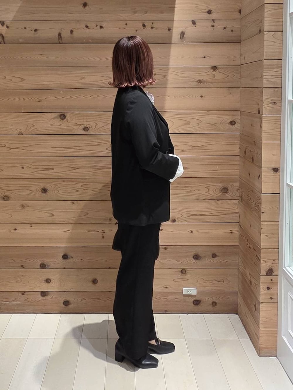 ブラック系のローファー、ブラック系のショルダーバッグ、ブラック系のテーラードジャケットを着用したレディースの冬コーディネートの2枚目の写真