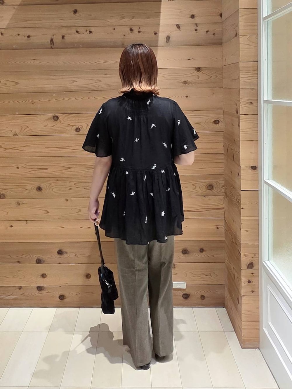 ブラウン系のその他パンツ、ホワイト系のタンクトップ、ブラック系のショルダーバッグを着用したレディースの夏コーディネートの3枚目の写真