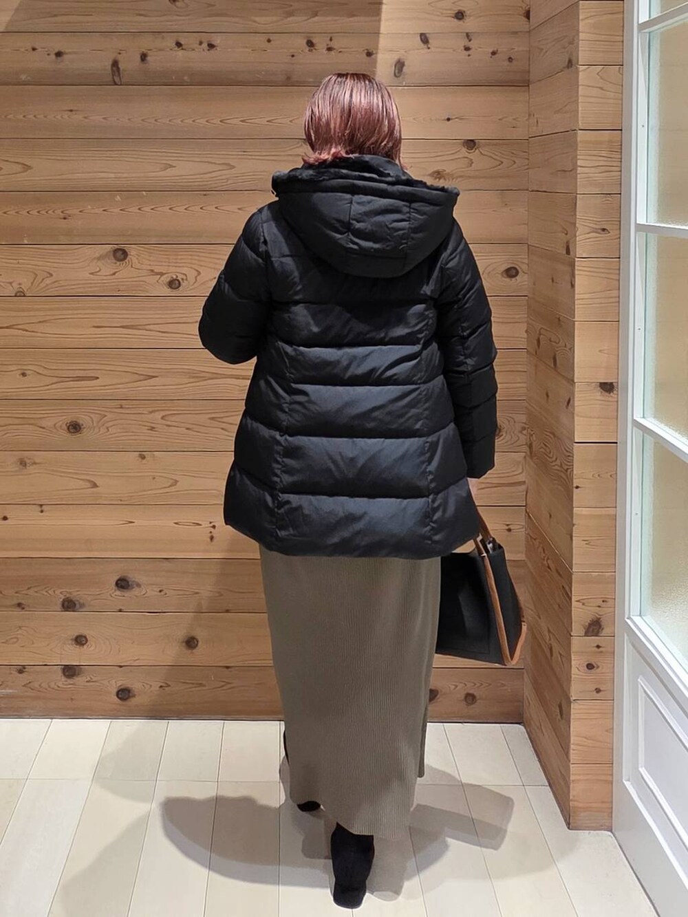 ブラック系のダウンジャケット/コート、ブラック系のスウェット、グリーン系のスカートを着用したレディースの秋コーディネートの3枚目の写真