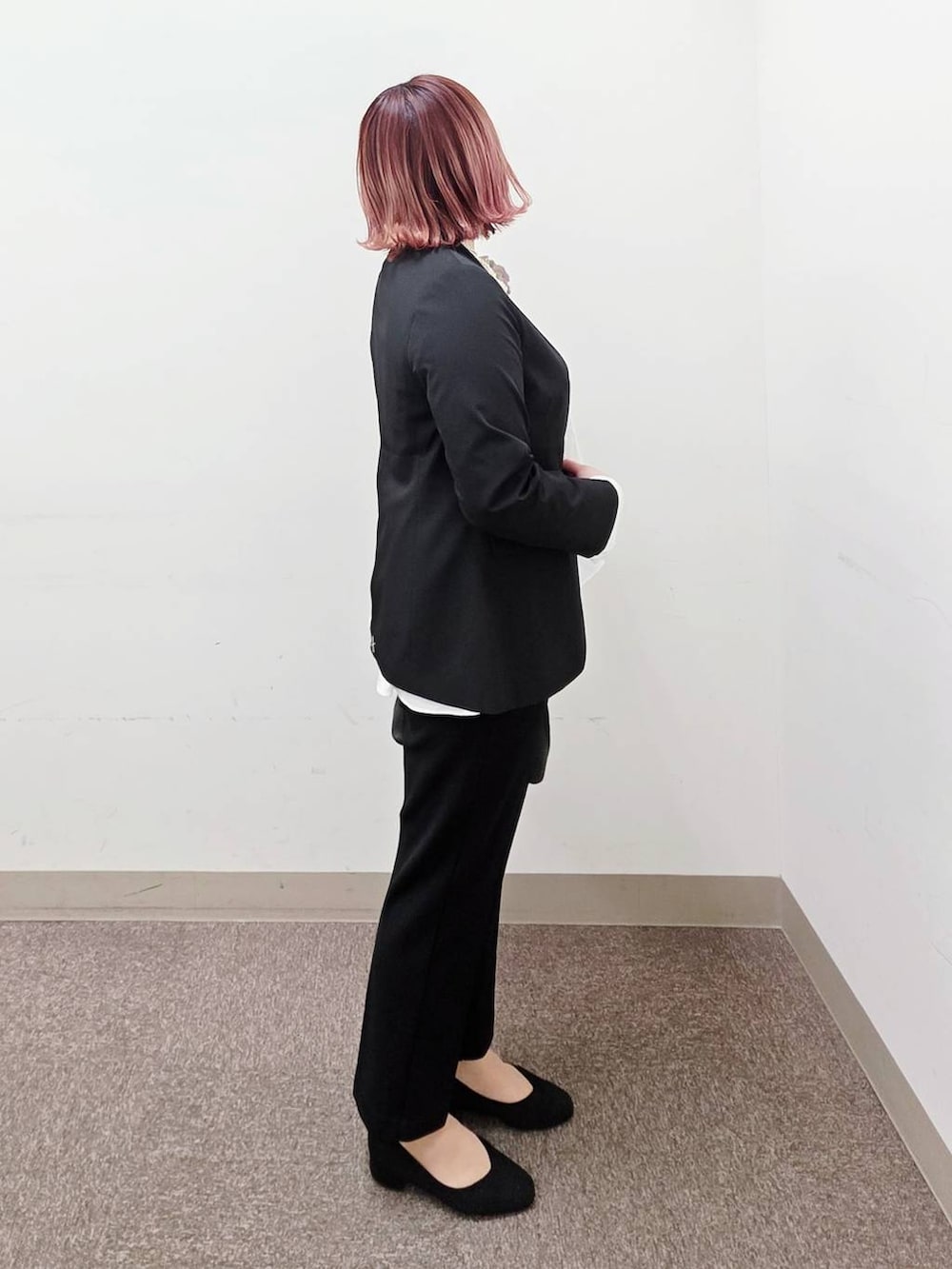 ブラック系のショルダーバッグ、ブラック系のパンプス、ブラック系のセットアップを着用したレディースの冬コーディネートの2枚目の写真