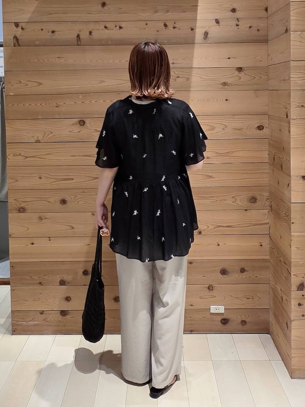 ベージュ系のその他パンツ、ホワイト系のタンクトップ、ブラック系のクラッチバッグを着用したレディースの夏コーディネートの3枚目の写真