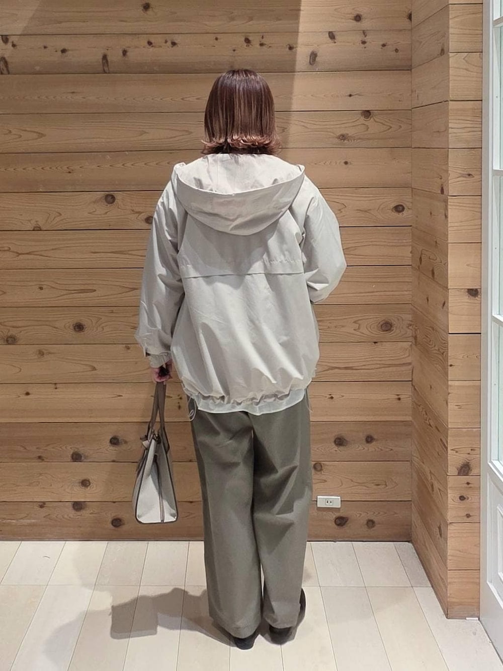 ブラック系のローファー、ホワイト系のショルダーバッグ、ベージュ系のマウンテンパーカーを着用したレディースの春コーディネートの3枚目の写真