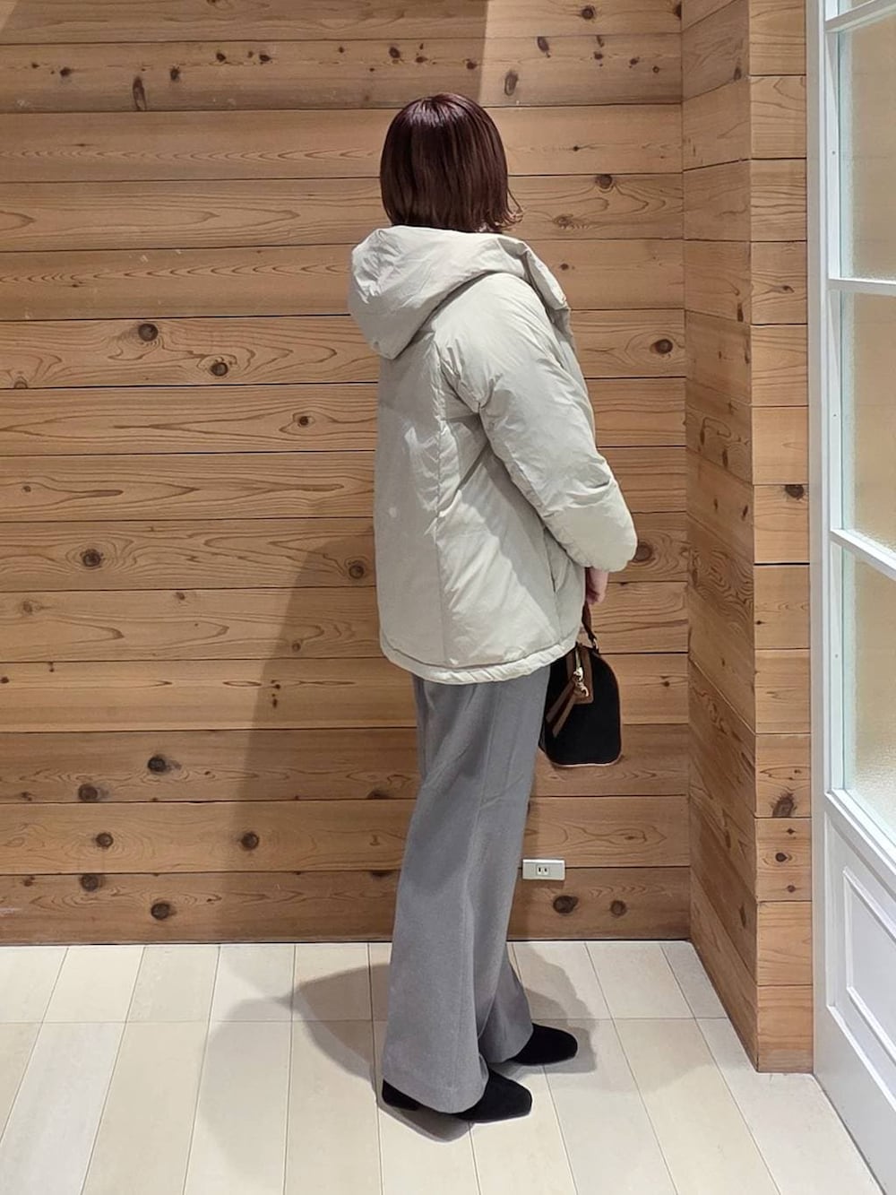 ベージュ系のダウンジャケット/コート、シルバー系のニット/セーター、グレー系のその他パンツを着用したレディースの冬コーディネートの2枚目の写真