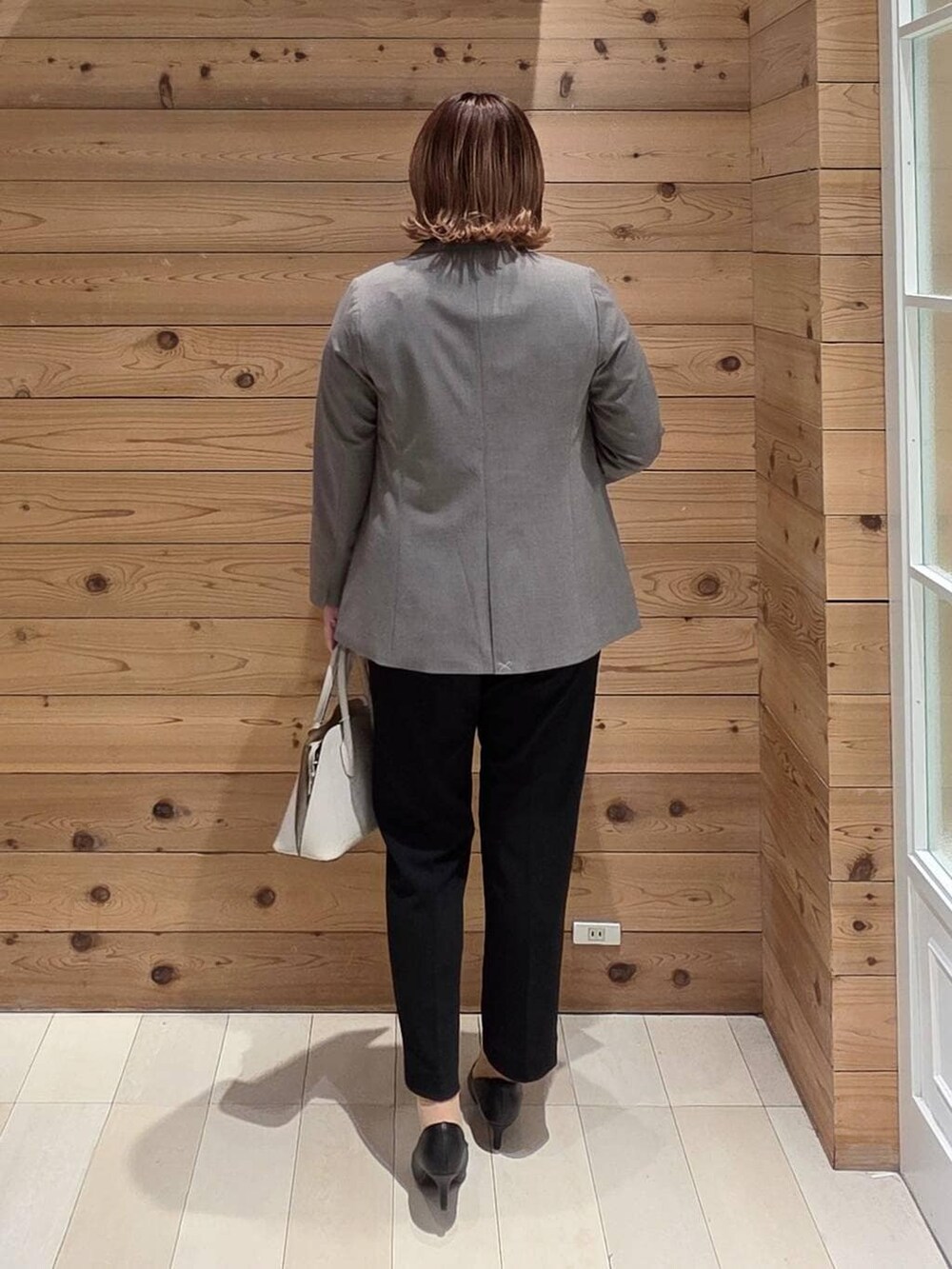 ホワイト系のショルダーバッグ、ブラック系のパンプス、ブルー系のシャツ/ブラウスを着用したレディースの冬コーディネートの3枚目の写真