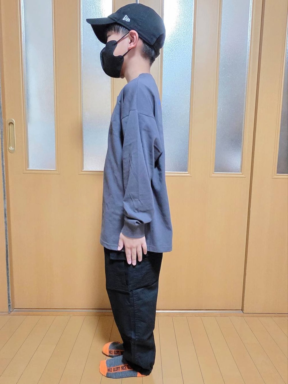 ブラック系のカーゴパンツ、グレー系のTシャツ/カットソー、ブラック系のキャップを着用したキッズの秋コーディネートの2枚目の写真