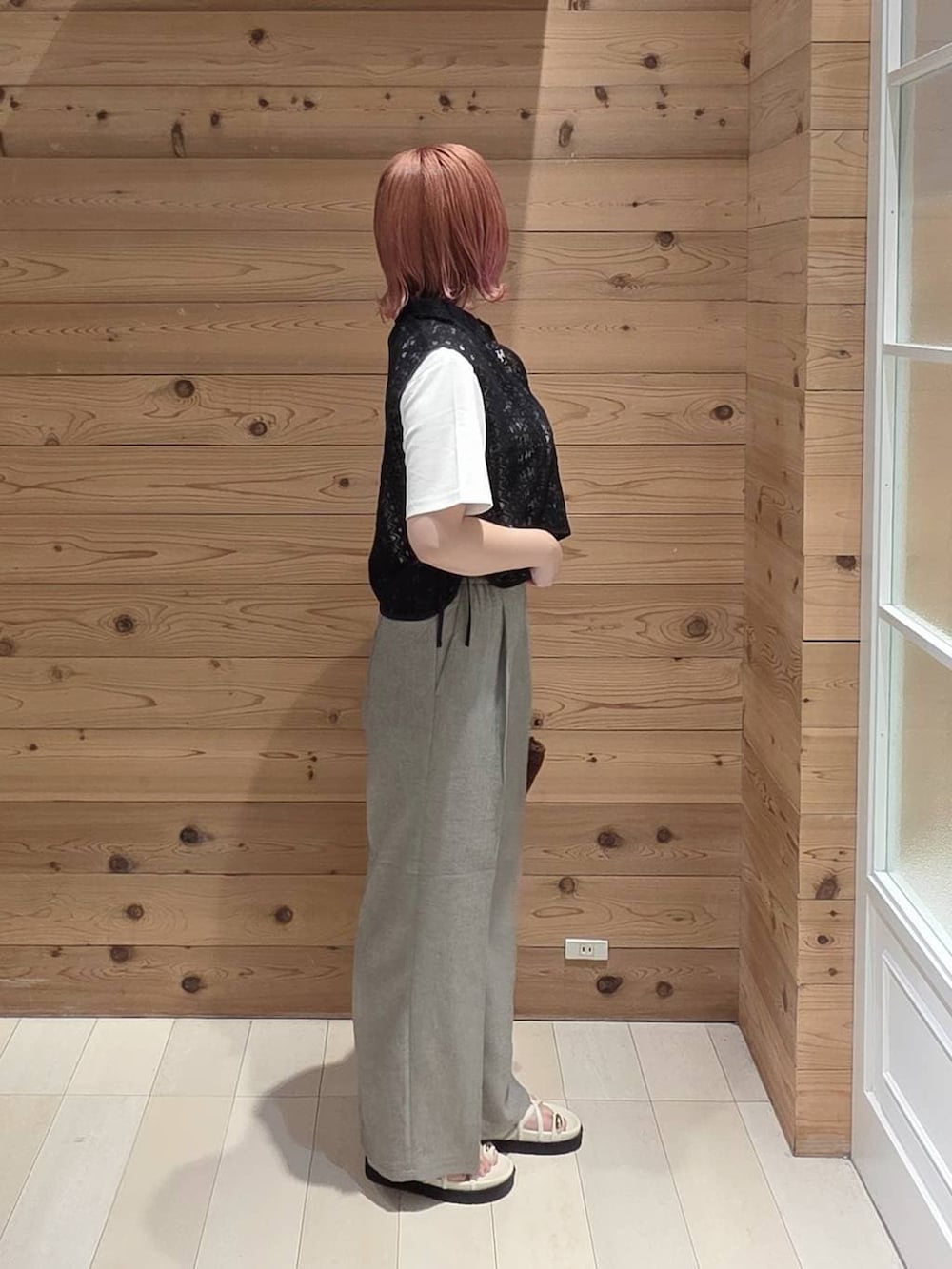 ベージュ系のその他パンツ、ホワイト系のTシャツ/カットソー、ブラウン系のクラッチバッグを着用したレディースの夏コーディネートの2枚目の写真