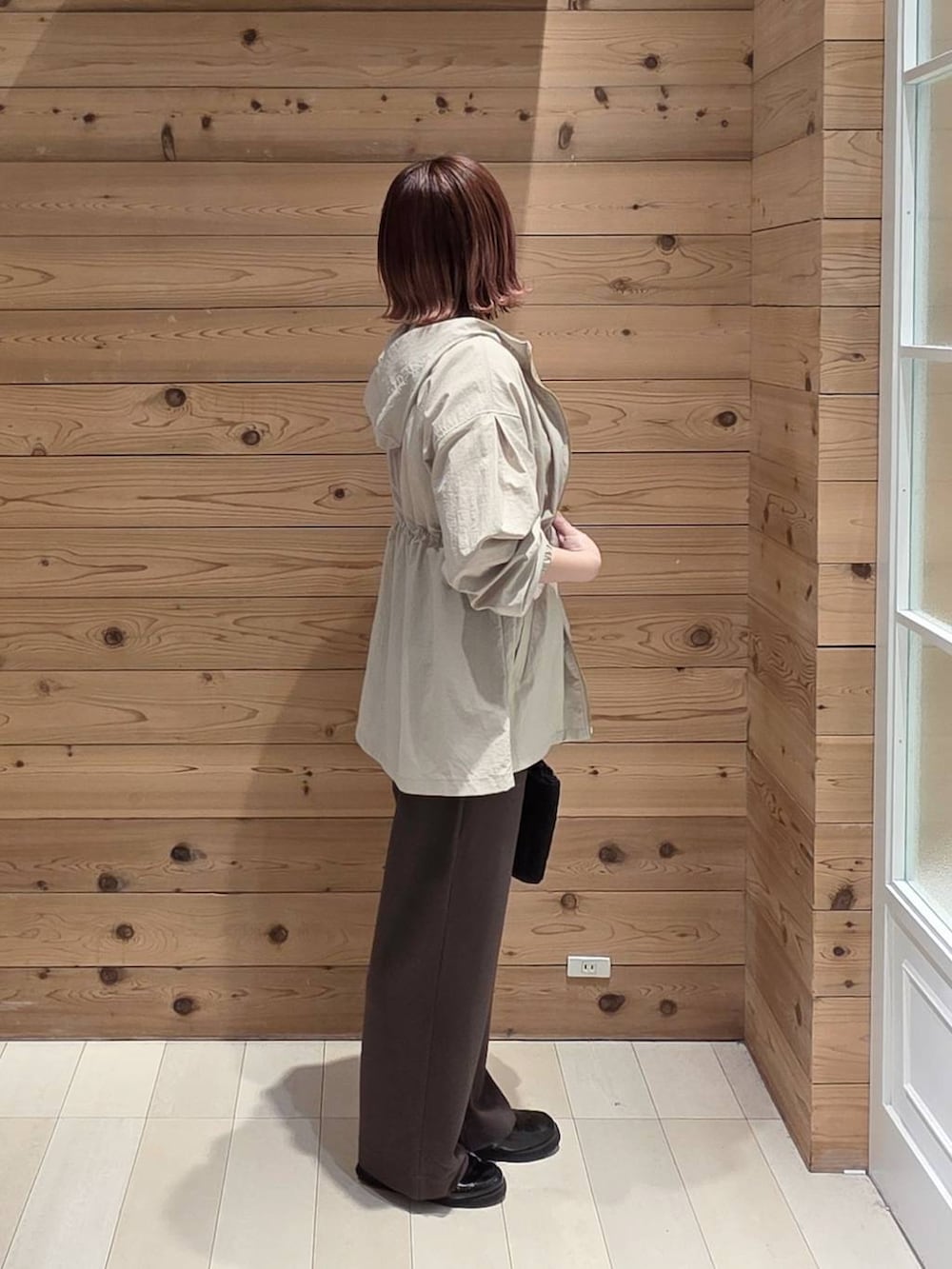 ブラック系のローファー、ベージュ系のパーカー、ブラウン系のその他パンツを着用したレディースの春コーディネートの2枚目の写真