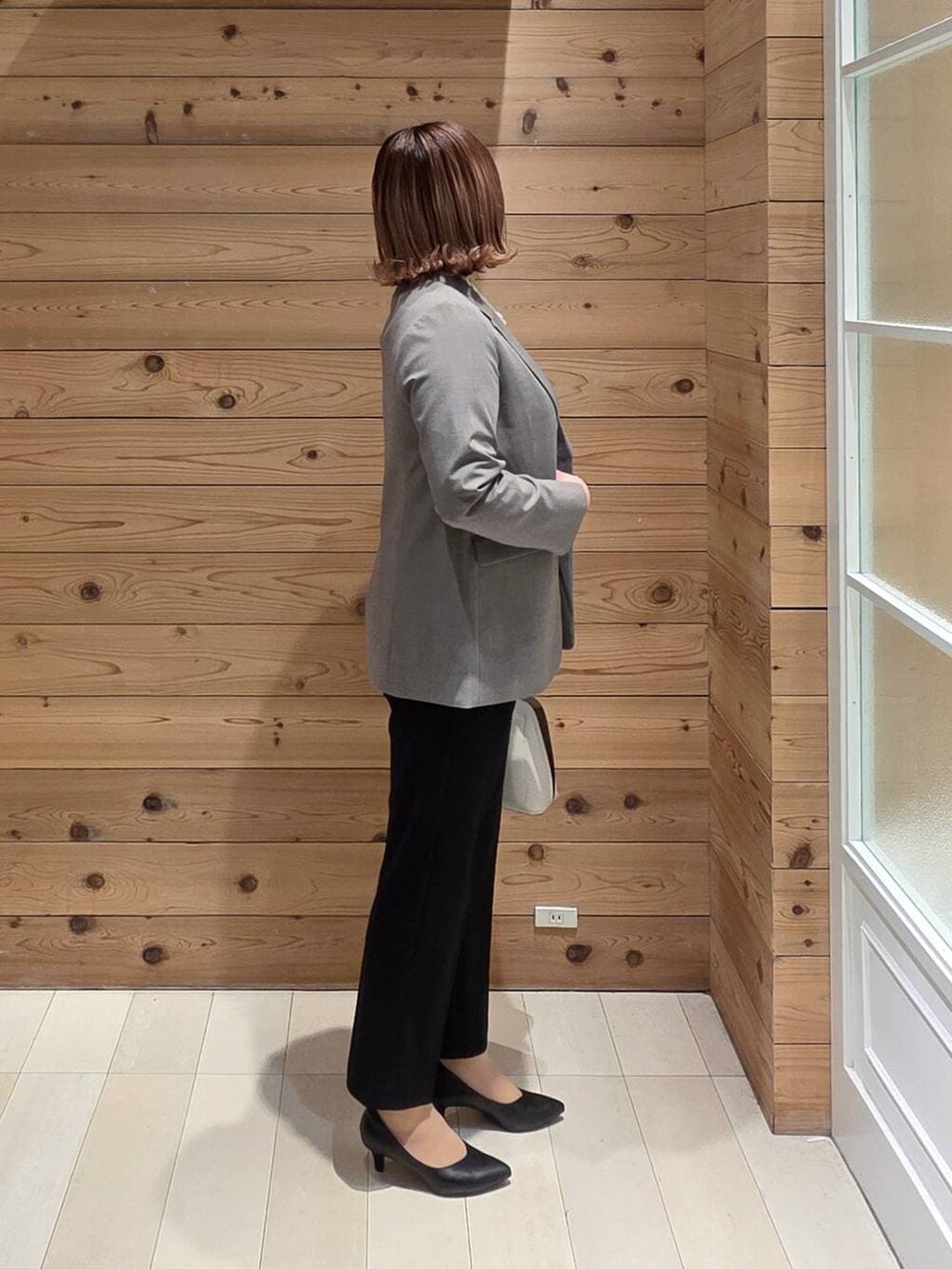 ホワイト系のショルダーバッグ、ブラック系のパンプス、ブルー系のシャツ/ブラウスを着用したレディースの冬コーディネートの2枚目の写真