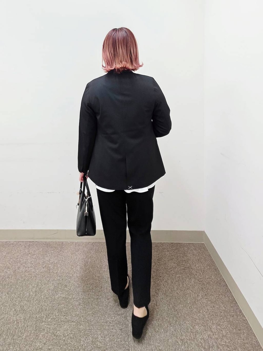 ブラック系のショルダーバッグ、ブラック系のパンプス、ブラック系のセットアップを着用したレディースの冬コーディネートの3枚目の写真