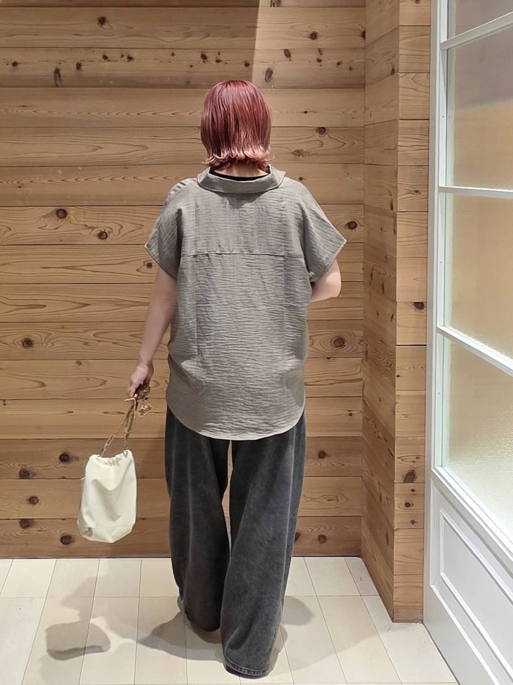 ブラック系のデニムパンツ、ブラック系のタンクトップ、ベージュ系のボディバッグ/ウエストポーチを着用したレディースの夏コーディネートの3枚目の写真