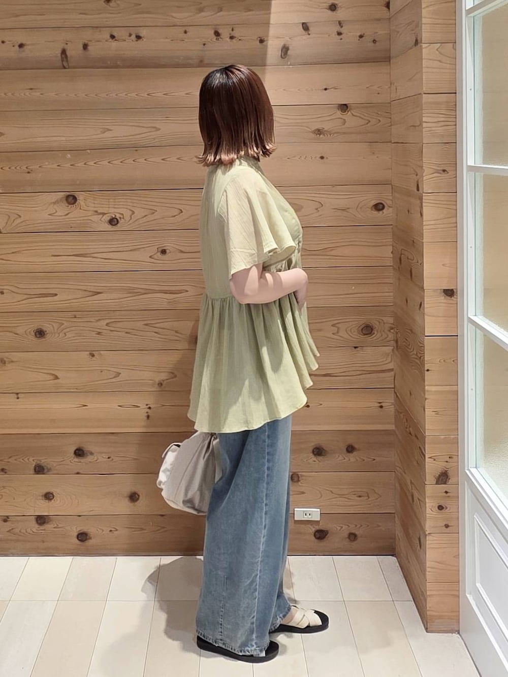 ブルー系のデニムパンツ、ホワイト系のタンクトップ、ベージュ系のサンダルを着用したレディースの夏コーディネートの2枚目の写真