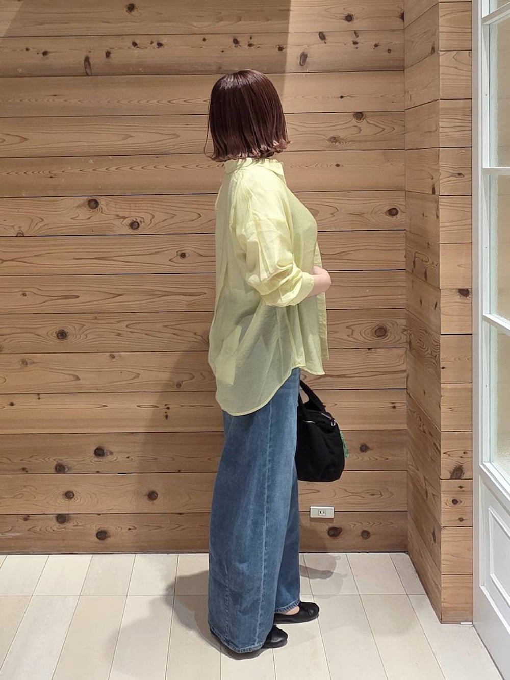 ブラック系のバレエシューズ、ブラック系のトートバッグ、ブルー系のデニムパンツを着用したレディースの春コーディネートの2枚目の写真
