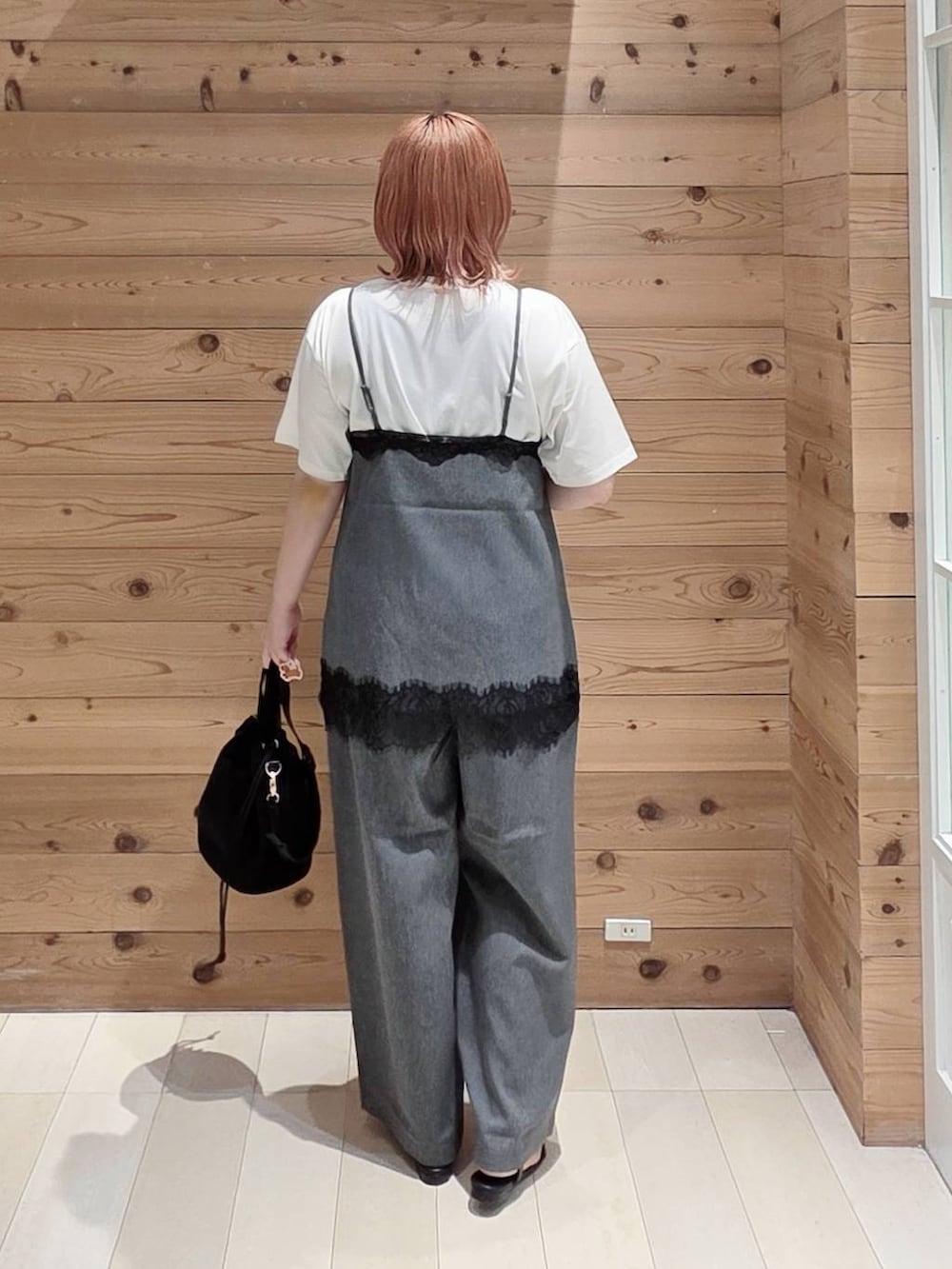 ブラック系のハンドバッグ、ホワイト系のTシャツ/カットソー、グレー系のキャミソールを着用したレディースの夏コーディネートの3枚目の写真
