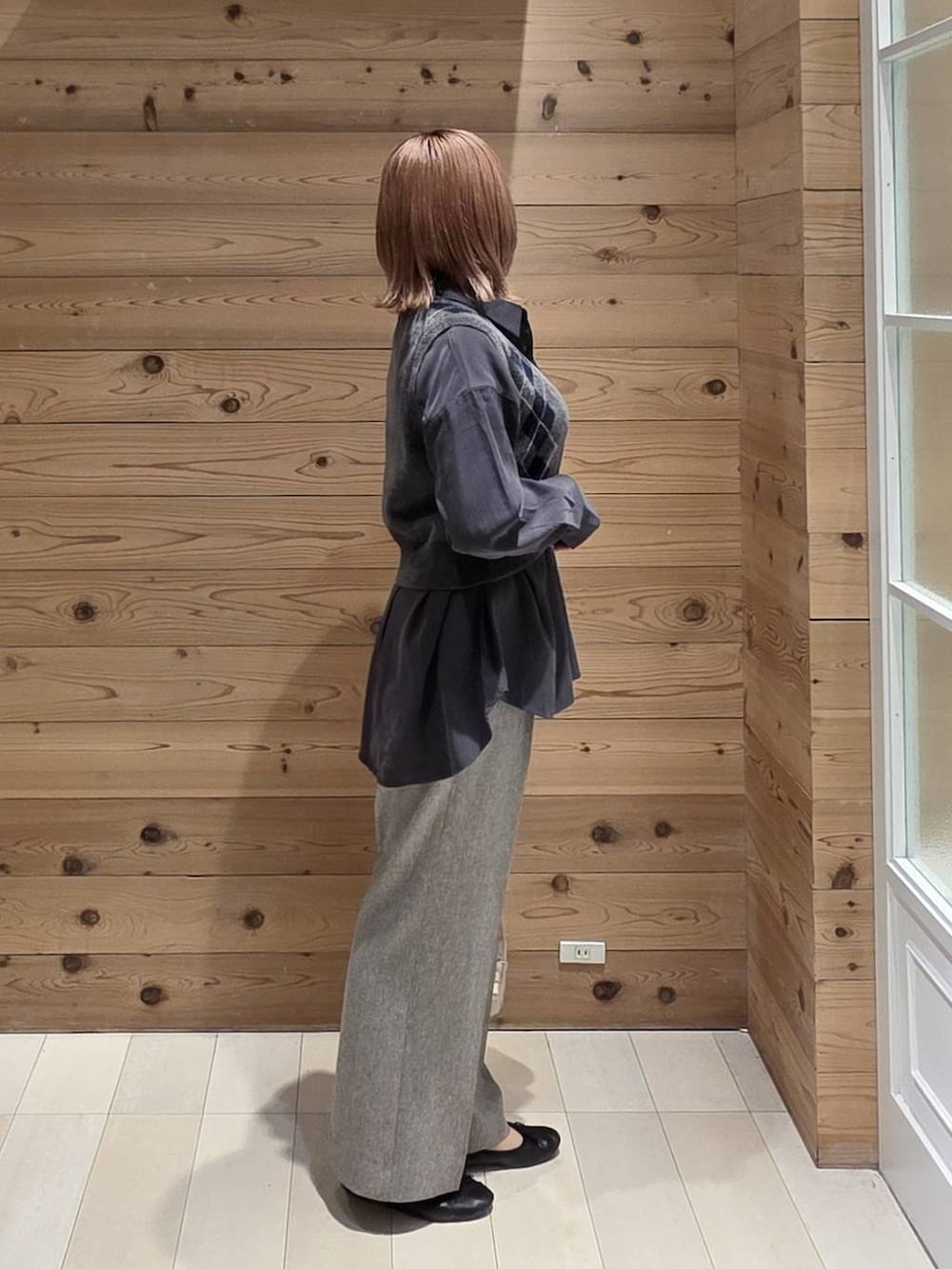 グレー系のベスト、グレー系のシャツ/ブラウス、ブラック系のバレエシューズを着用したレディースの秋コーディネートの2枚目の写真