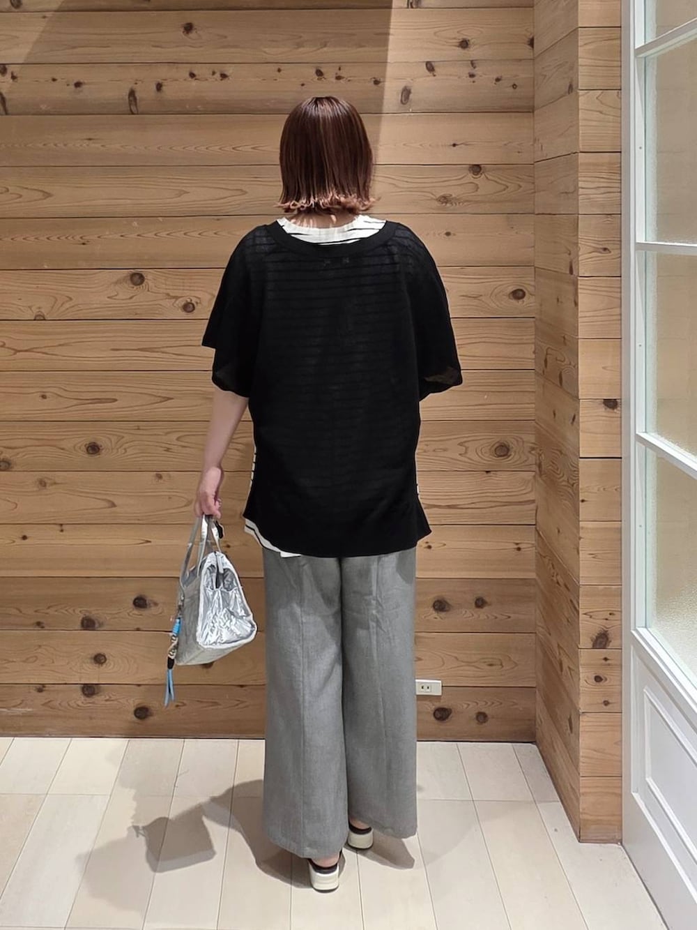 シルバー系のボストンバッグ、グレー系のその他パンツ、ホワイト系のTシャツ/カットソーを着用したレディースの夏コーディネートの3枚目の写真