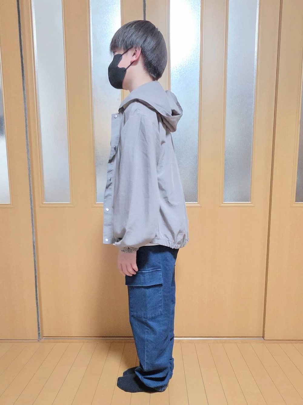 ベージュ系のマウンテンパーカー、ブルー系のカーゴパンツ、ホワイト系のTシャツ/カットソーを着用したキッズの春コーディネートの2枚目の写真