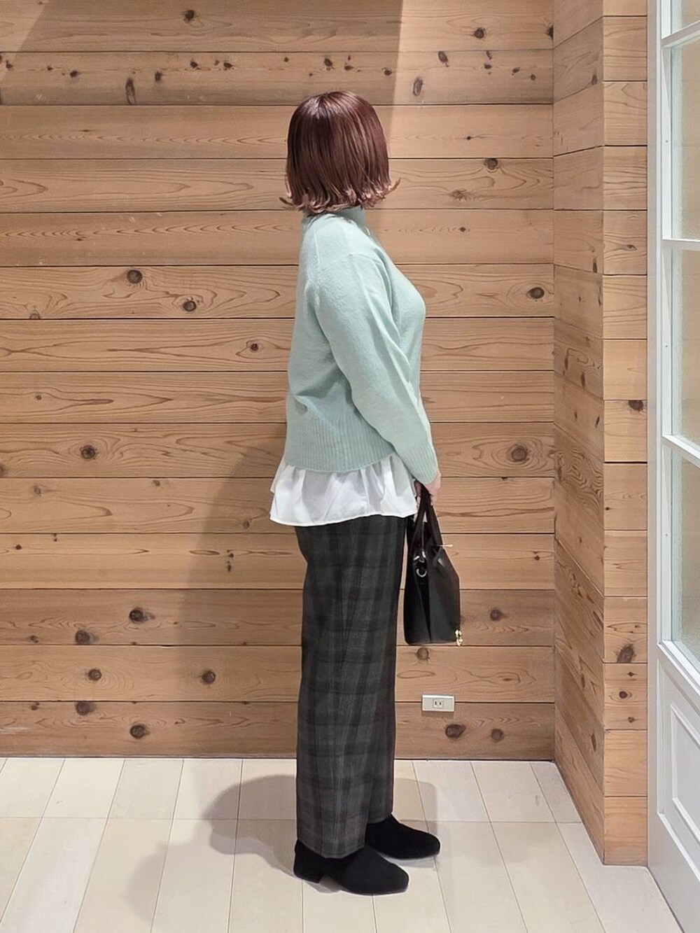 ブラック系のショルダーバッグ、ブラック系のダウンジャケット/コート、ブラック系のその他パンツを着用したレディースの冬コーディネートの2枚目の写真