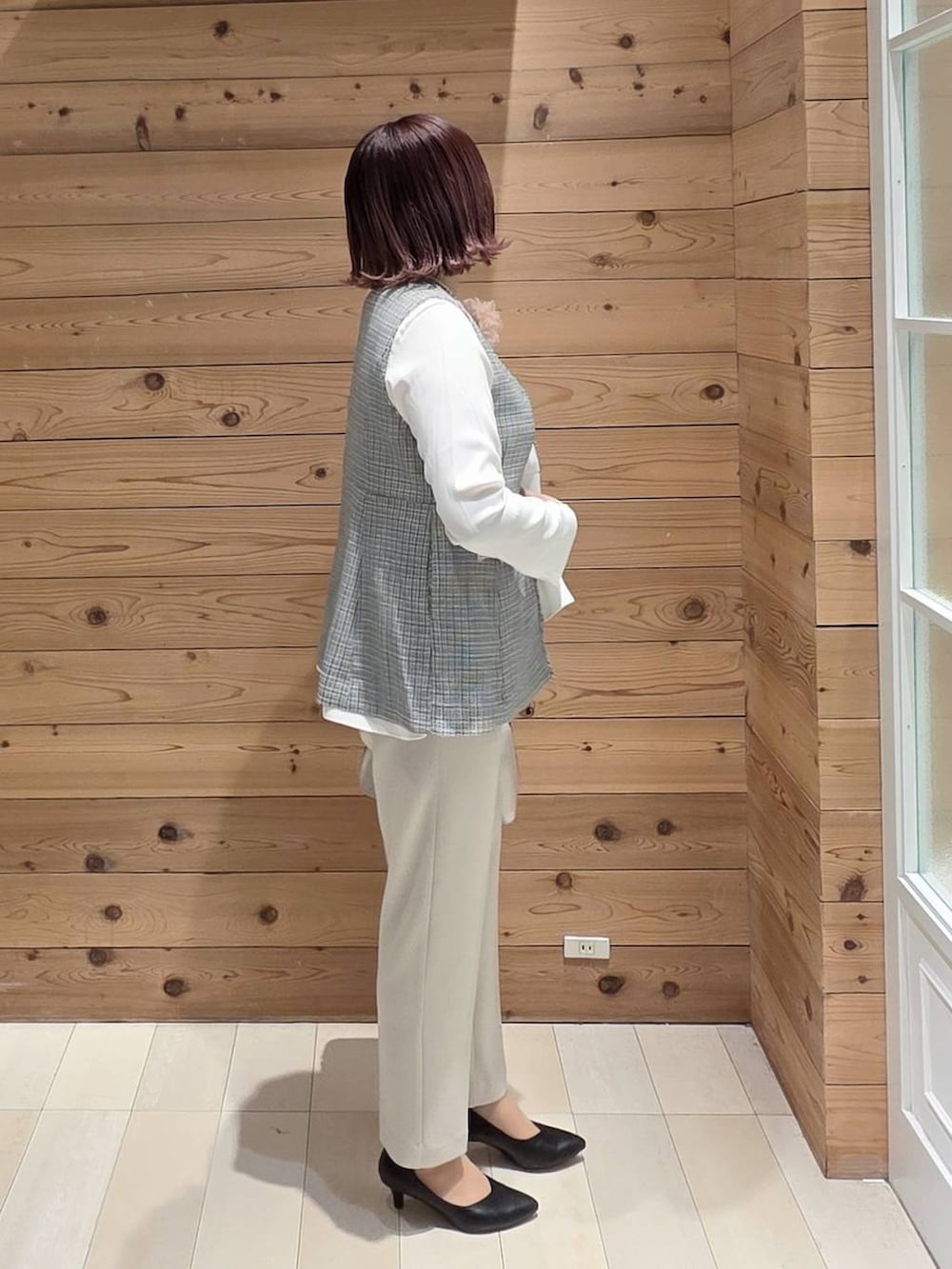 ホワイト系のショルダーバッグ、ブラック系のパンプス、ベージュ系のセットアップを着用したレディースの冬コーディネートの2枚目の写真