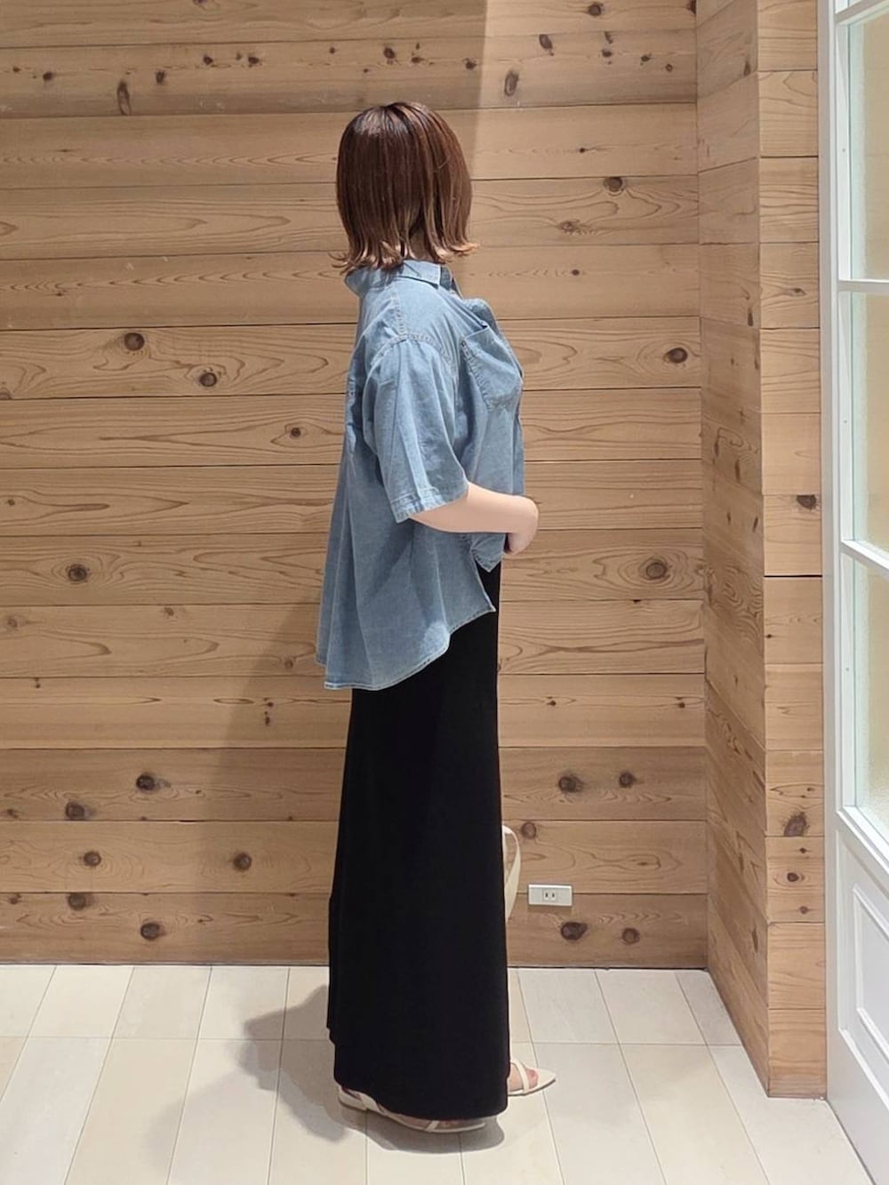 ブルー系のシャツ/ブラウス、ブラック系のスカート、ホワイト系のTシャツ/カットソーを着用したレディースの夏コーディネートの2枚目の写真